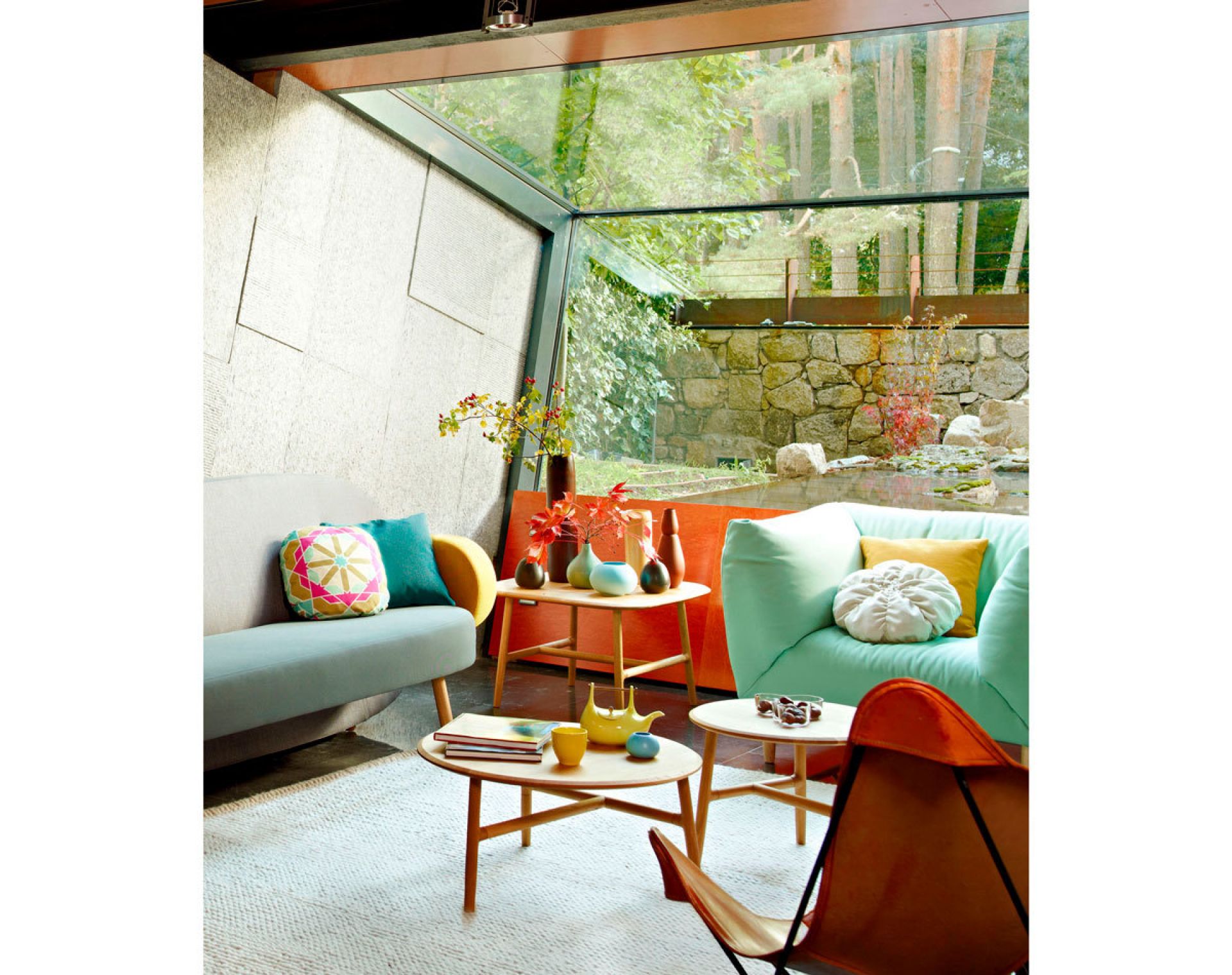 Wohnzimmer-Szene mit Nudo Beistelltisch von Sancal, runder Holztisch für Bücher und Dekoration.