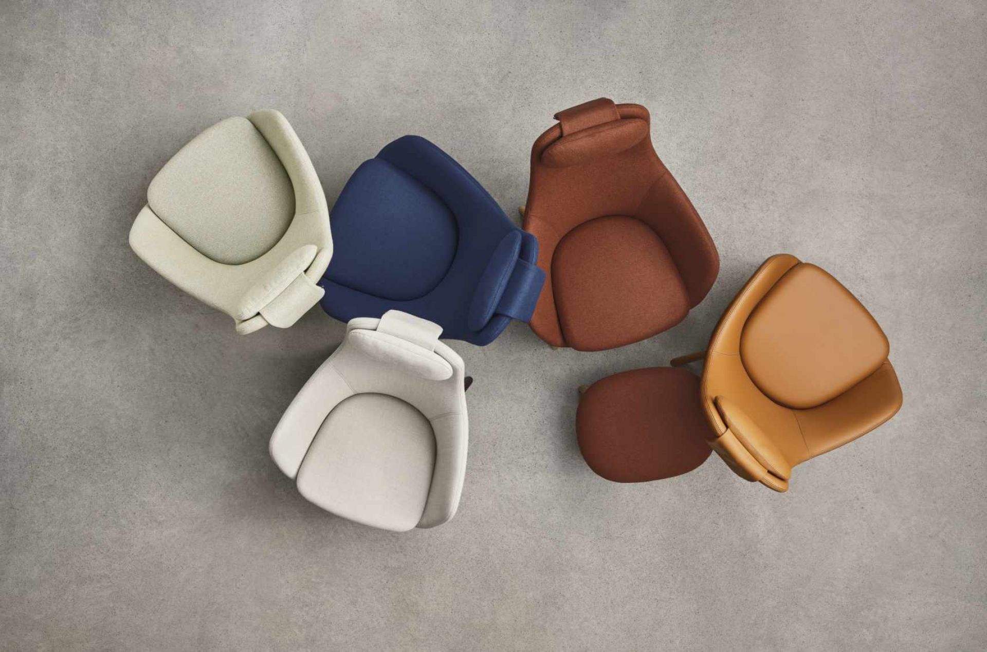Fünf Vitra Hal Lounge Chair Sessel Sitzkissen in verschiedenen Farben von oben auf grauem Untergrund.