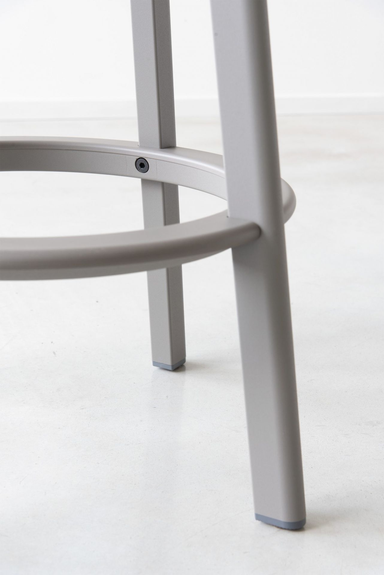 Detailaufnahme des grauen Déjà-vu Barhockers von Magis: Beine, Fußstütze und Bodengleiter.