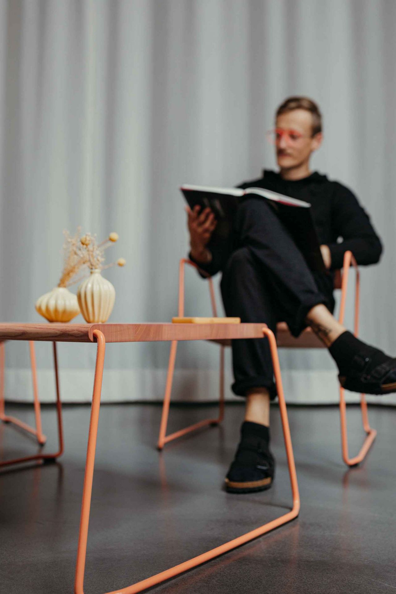 Moderner Couchtisch "Fuchs & Habicht" mit orangefarbenem Gestell und Holzplatte, ideal für Wohnzimmer.