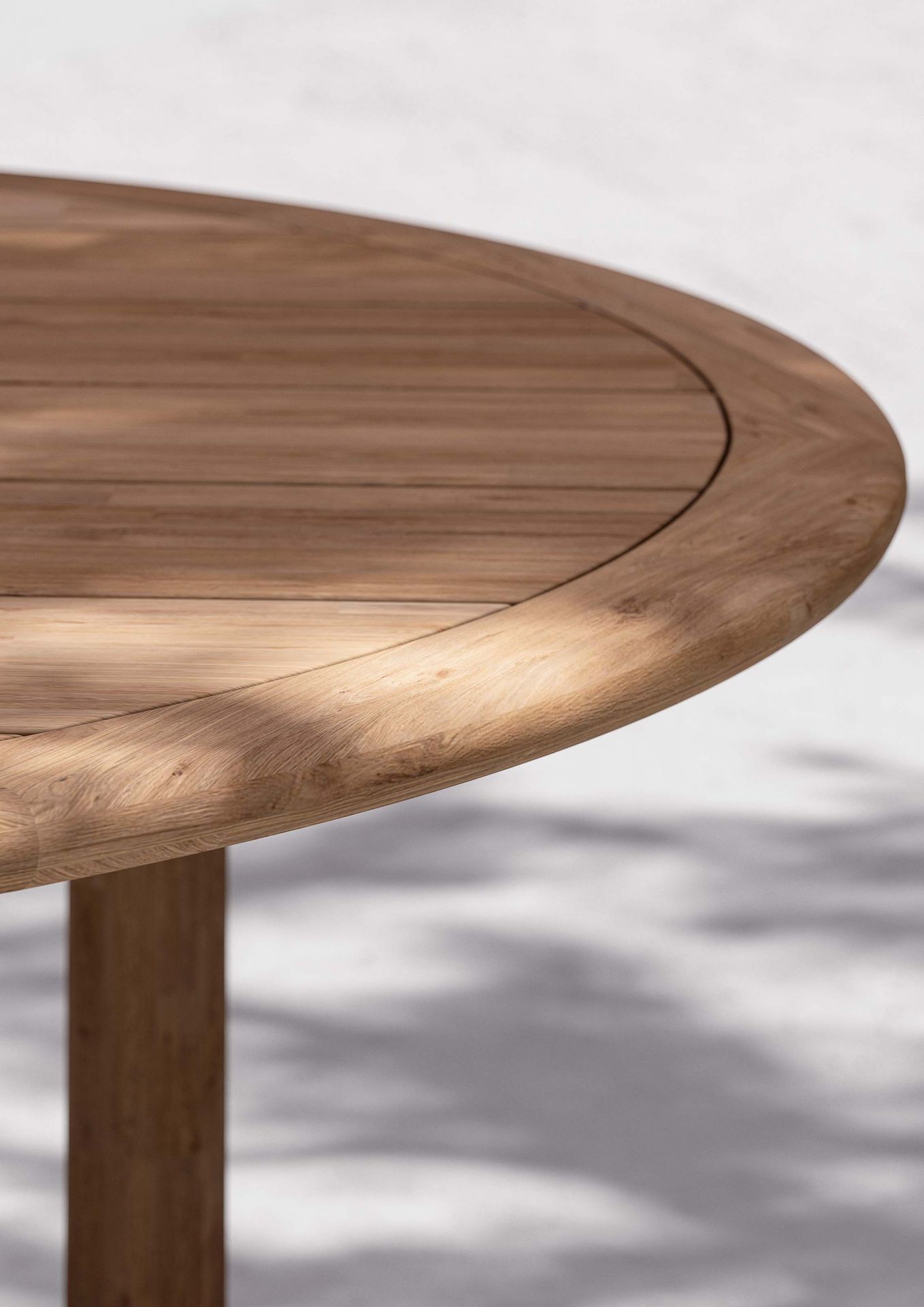 Detailaufnahme der runden Tischplatte des Tibbo Gartentisches von Dedon aus massivem Teakholz.