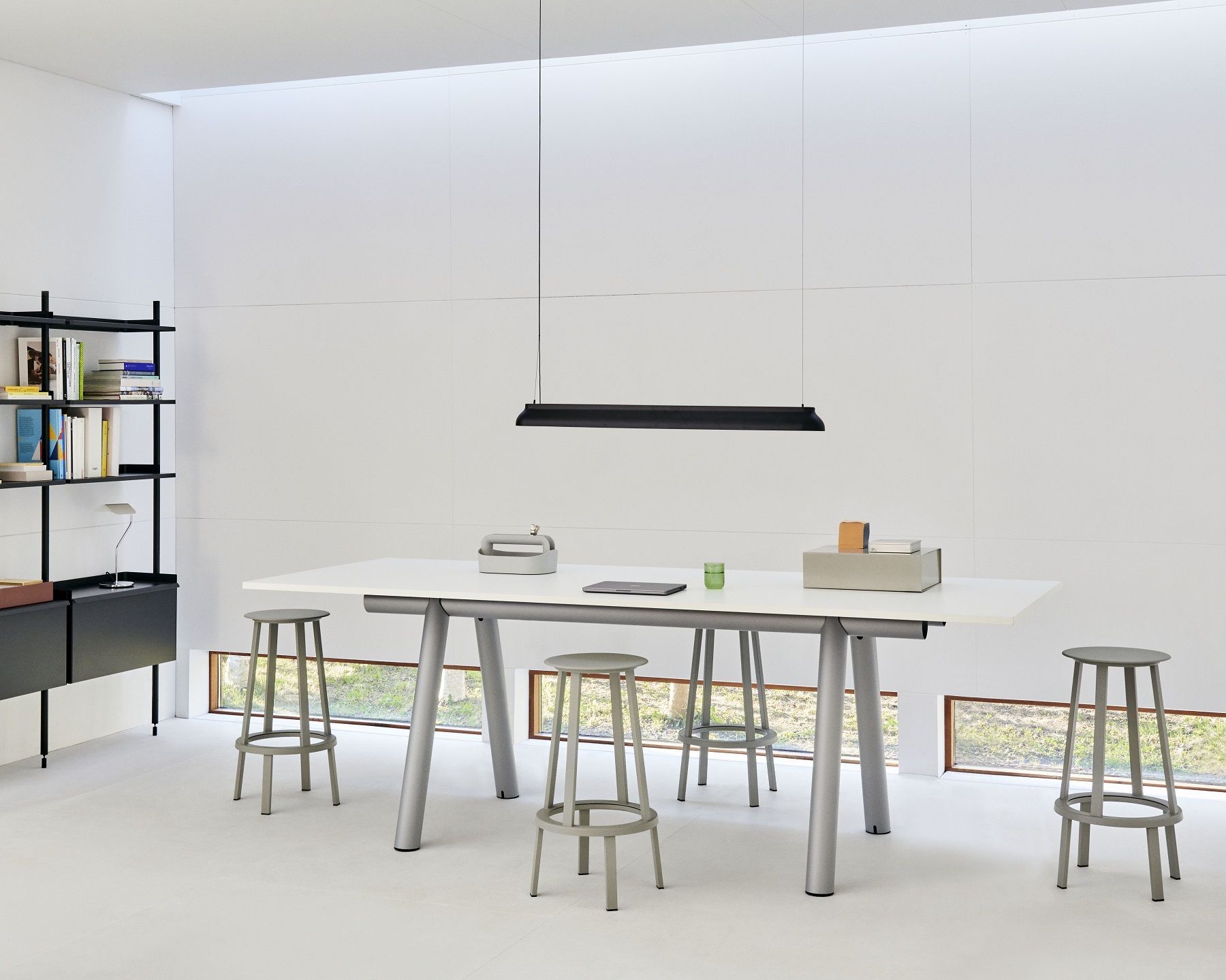 Weißer Hay Boa Table Tisch mit silbernen Beinen und grauen Hockern in hellem Raum.