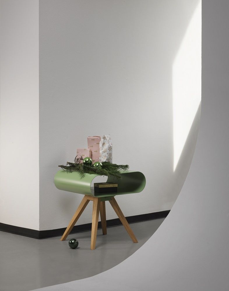 LO 12 Beistelltisch von Müller Möbelfabrikation in Grün mit Holzbeinen und Ablagefläche. Dekoriert mit Geschenken.