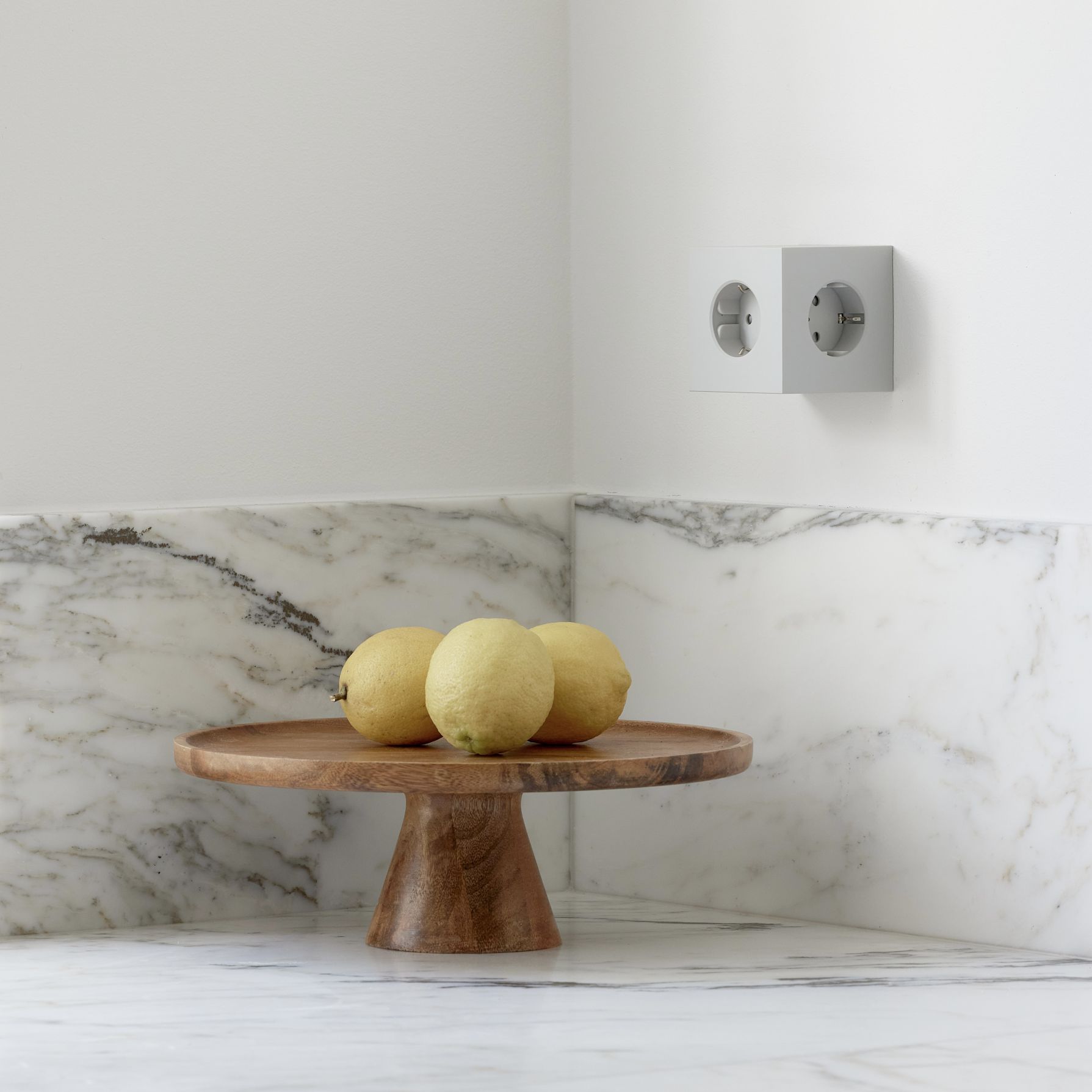 Avolt Square 2 Steckdosenwürfel in Gotland Grau an Wand, mit USB-C und Zitronen.