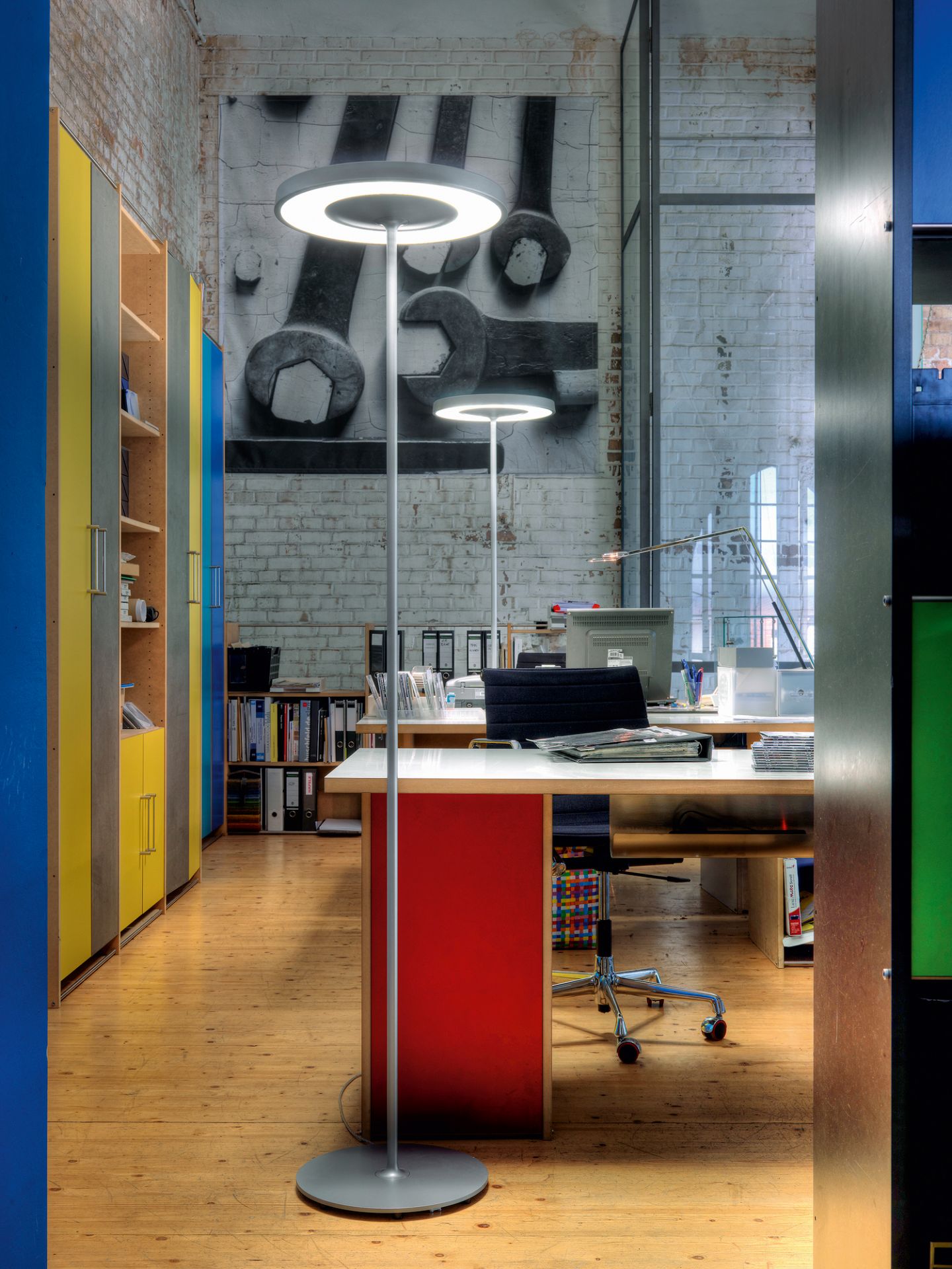 Disk Stehleuchte von Belux im Büro: Moderne LED-Stehlampe mit runder Leuchtfläche.