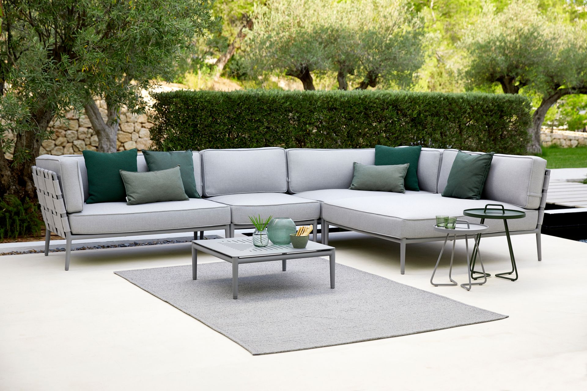 Conic AirTouch Daybed Modul von Cane-Line: Graues Outdoor Sofa mit grünen Kissen.