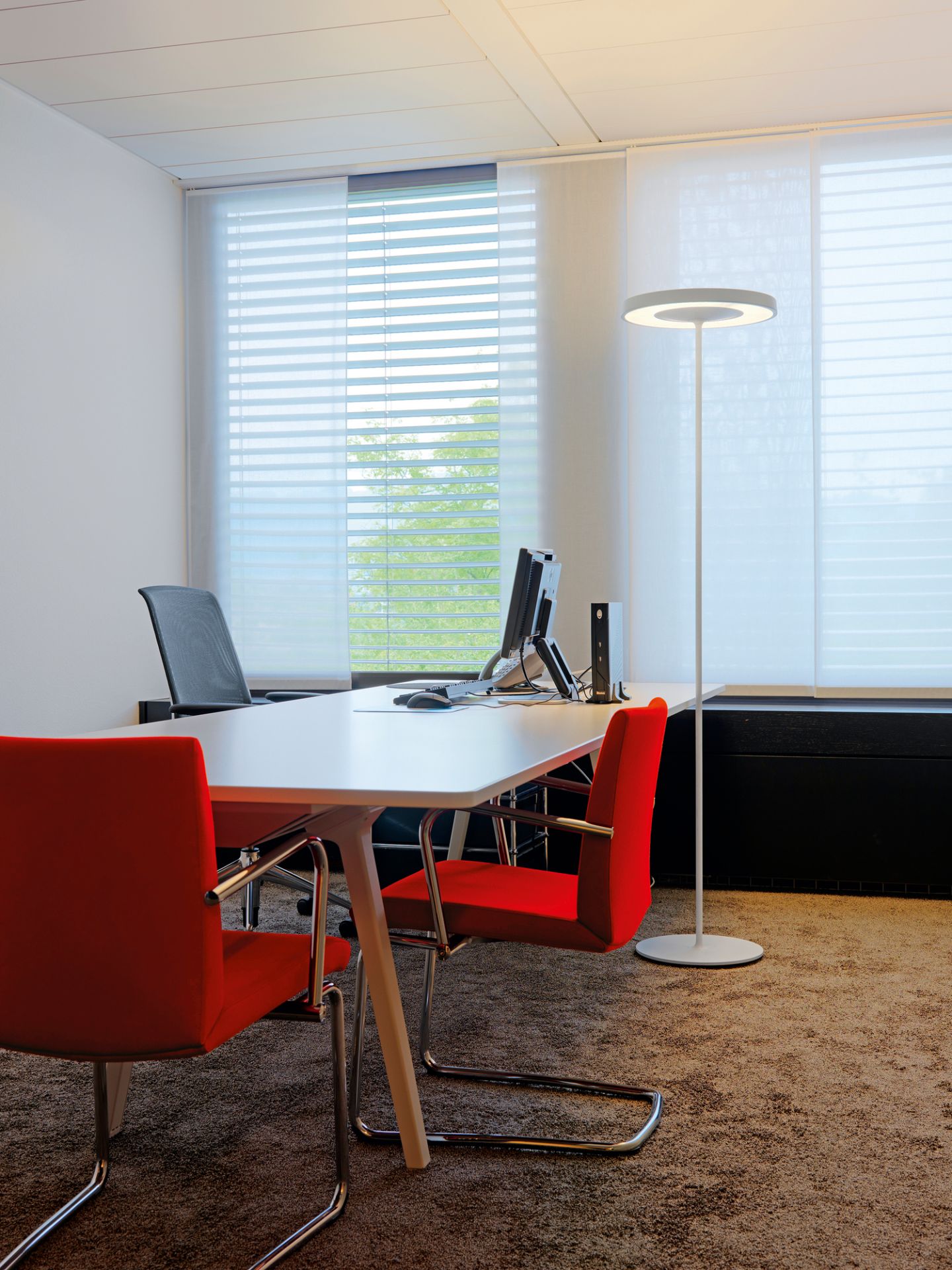 Büro mit Belux Disk Stehleuchte: Moderne LED-Stehlampe sorgt für angenehmes Licht.