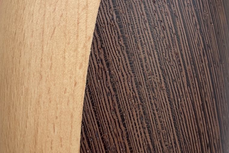 Detailaufnahme Holzmaserung des Architectmade Pinguin, helles und dunkles Holz, dekorative Holzfigur.