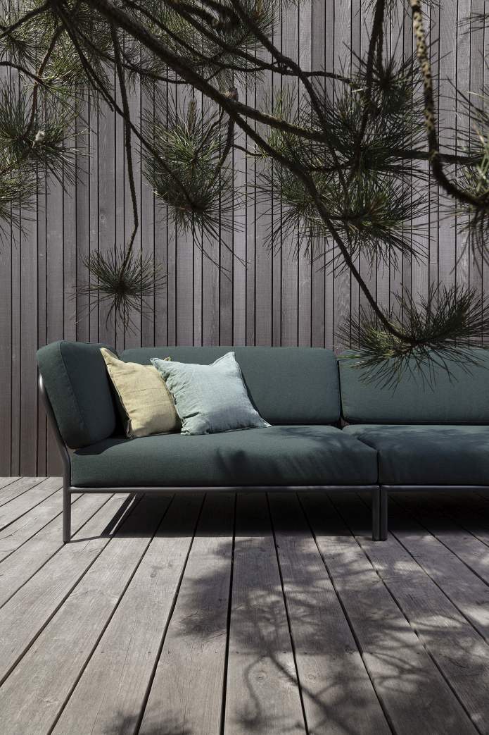 Houe Level Outdoor Sofa Ecke links, dunkelgrün, mit Kissen auf Holzterrasse.