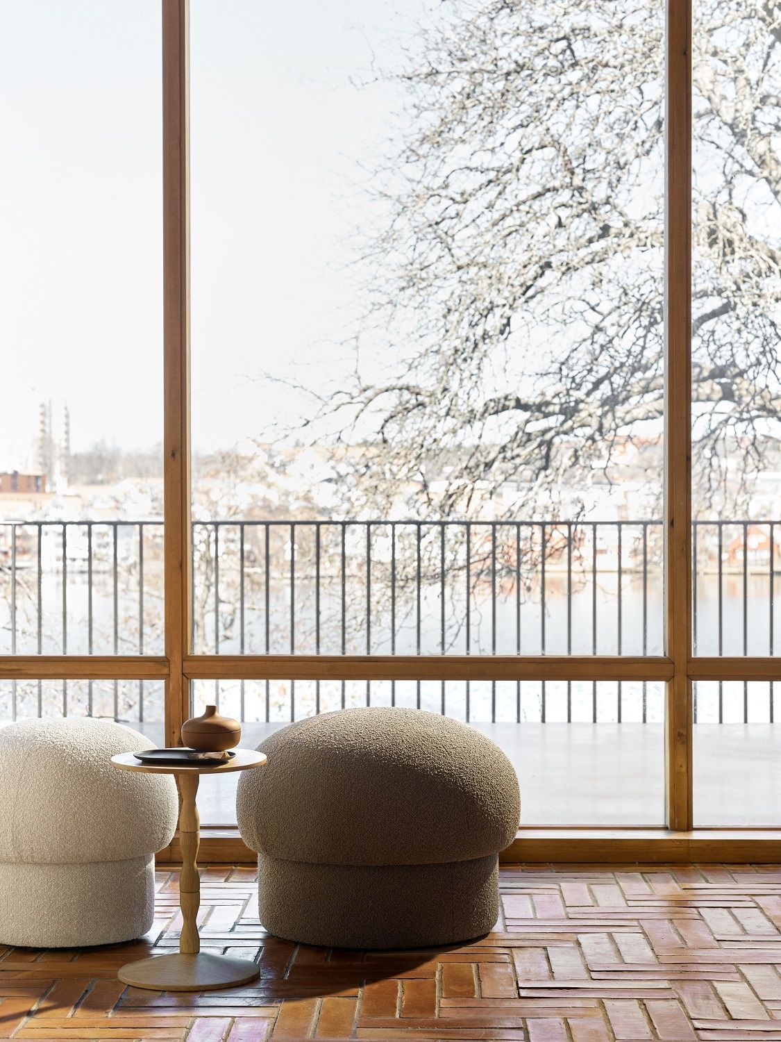 Uno Pouf Hocker von Design House Stockholm, beige und braun, vor großem Fenster.