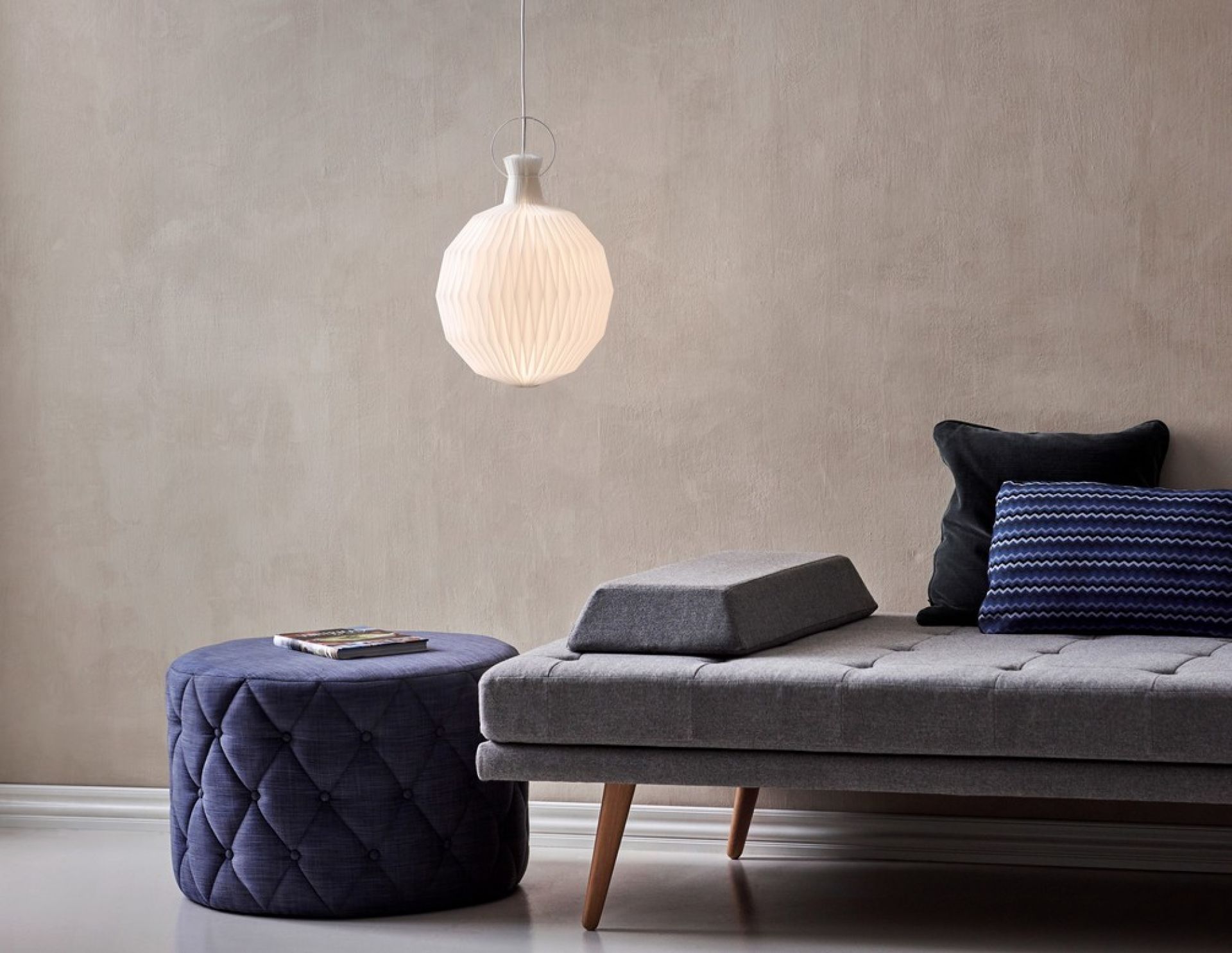 Le Klint Model 101 Pendelleuchte mit Medium Papierschirm, hängend über einem modernen Wohnbereich.