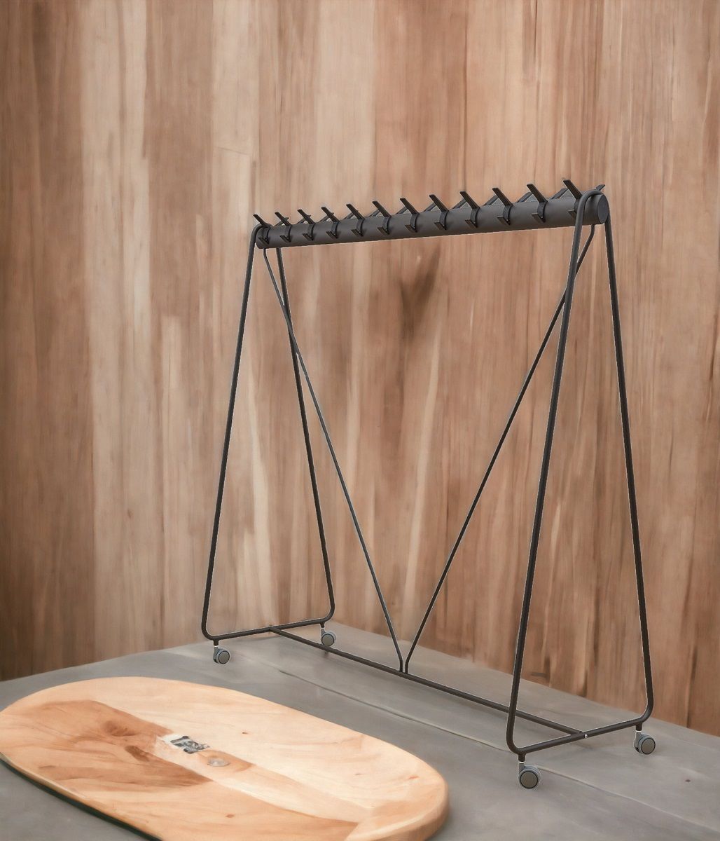 Schwarze Ellipse Garderobe von Segis mit 24 Haken und Rollen vor Holzwand.