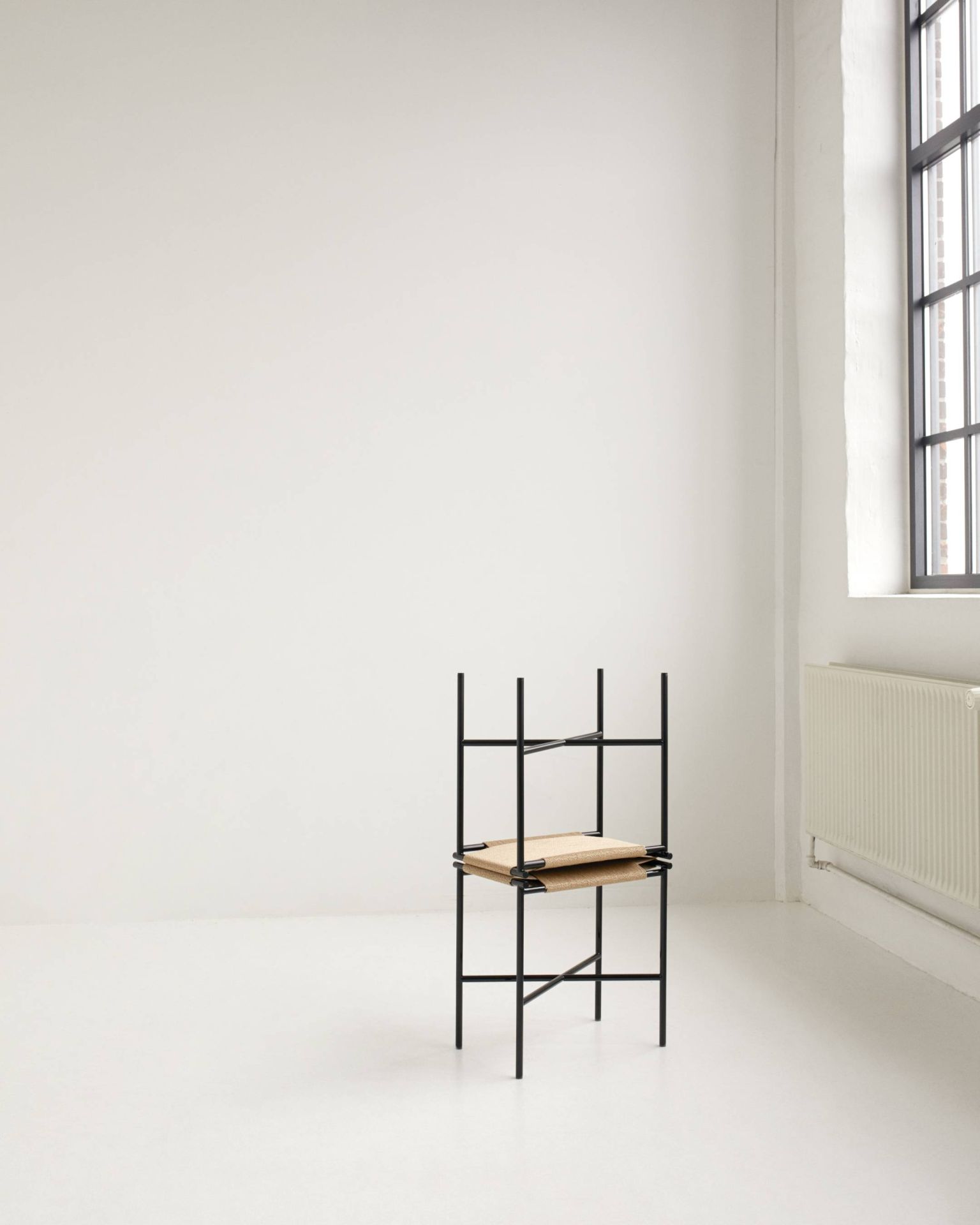 Vent Hocker von Skagerak by Fritz Hansen, minimalistisches Design mit schwarzem Gestell und geflochtener Sitzfläche.