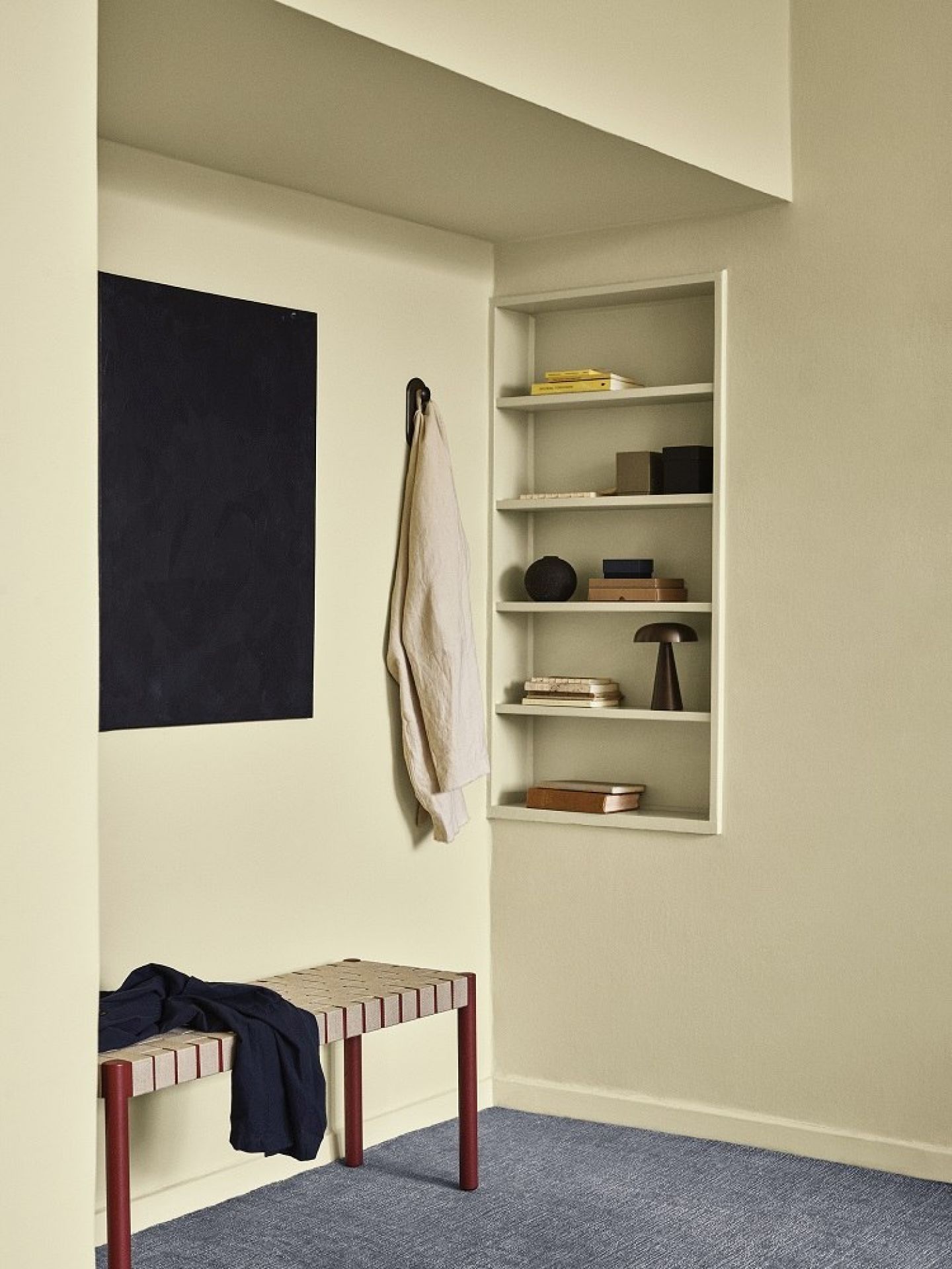 AndTradition Betty Bank TK4/TK5: Moderne Sitzbank mit Textilgewebe und roten Beinen im Flur.