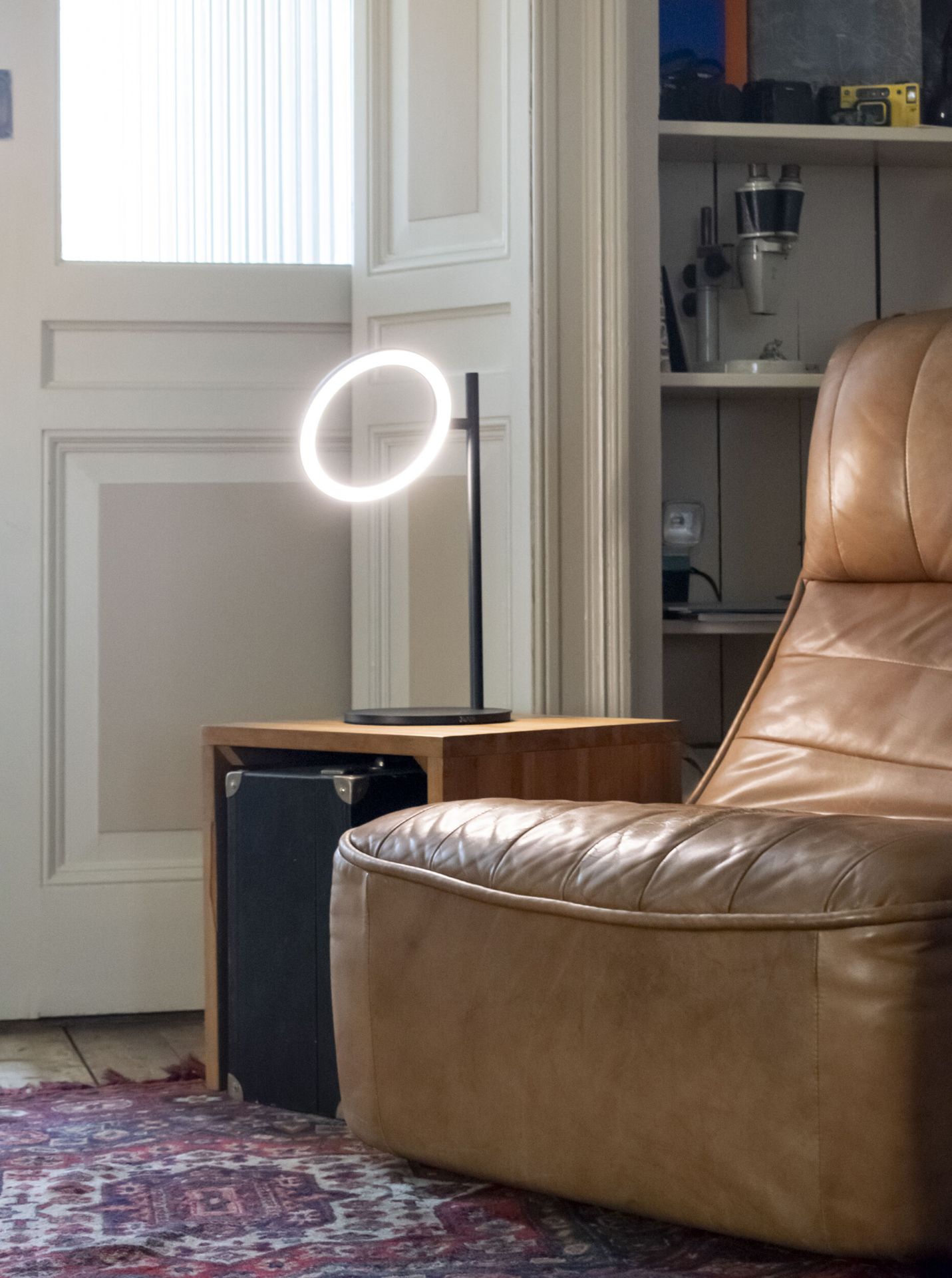 Echo Small Akkuleuchte: Moderne Tischleuchte mit ringförmigem Licht auf einem Nachttisch.