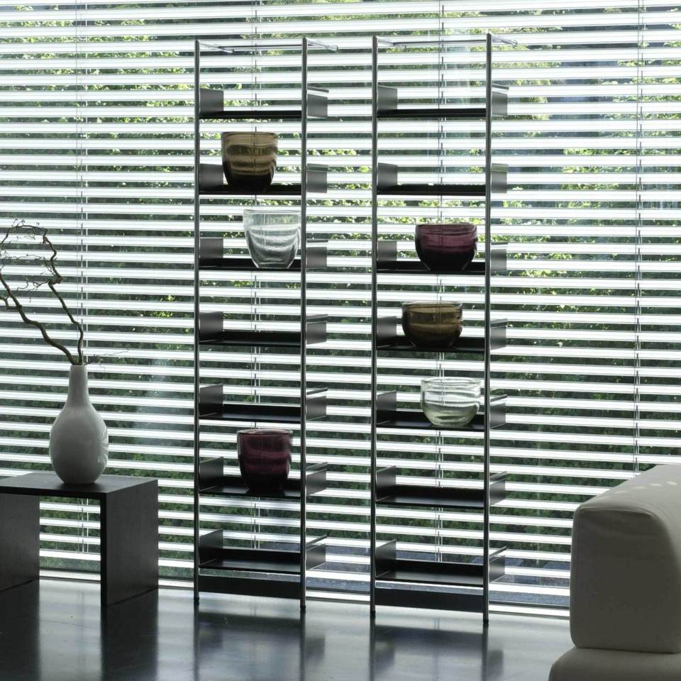 Schwarzes Pool 196 Anlehnregal von Mox mit Glasvasen vor einem Fenster mit Jalousien.