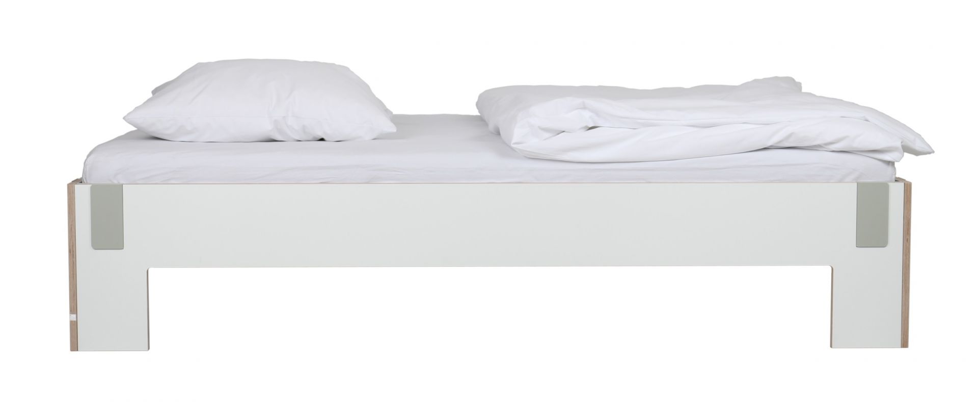 Modernes Bett von Nils Holger Moormann mit weißem Bezug und minimalistischer Holzstruktur.
