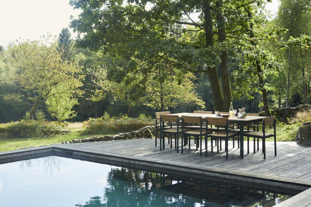 Pelagus Tisch von Skagerak by Fritz Hansen neben Pool auf Holzterrasse im Garten.