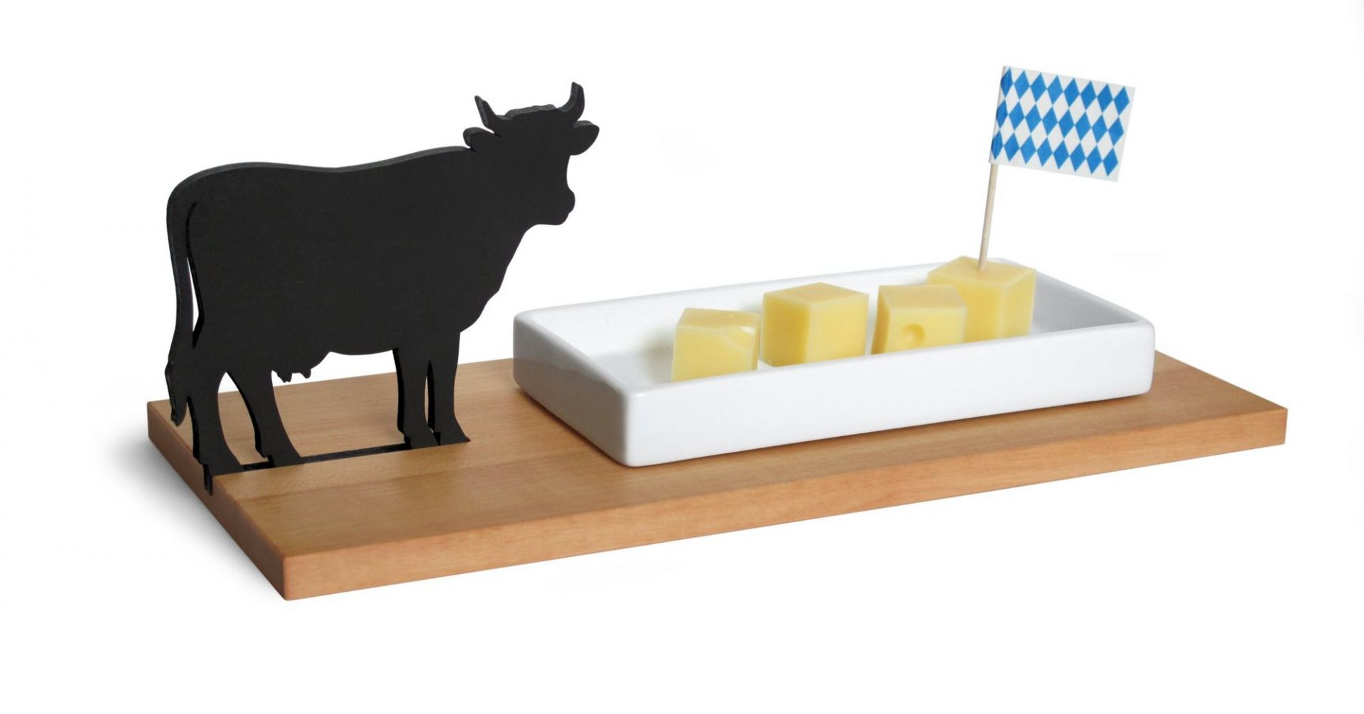Käseschale mit Kuh-Motiv: Servierplatte aus Holz mit Käsewürfeln und bayerischer Flagge.