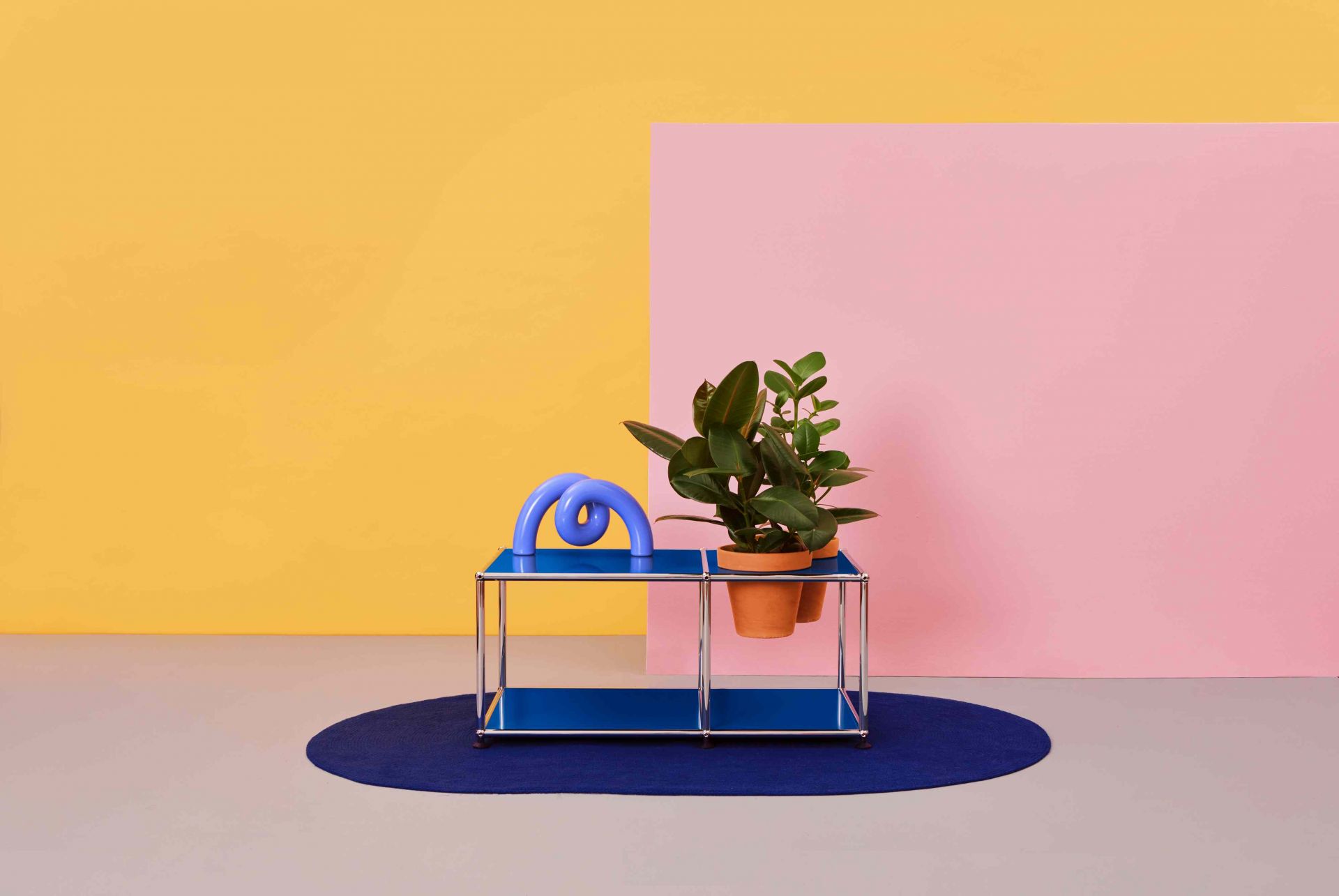 Pflanzenwelten Beistelltisch, blau, mit Pflanze und Dekoration vor gelbem und pinkem Hintergrund. Moderner Beistelltisch für Wohnzimmer.