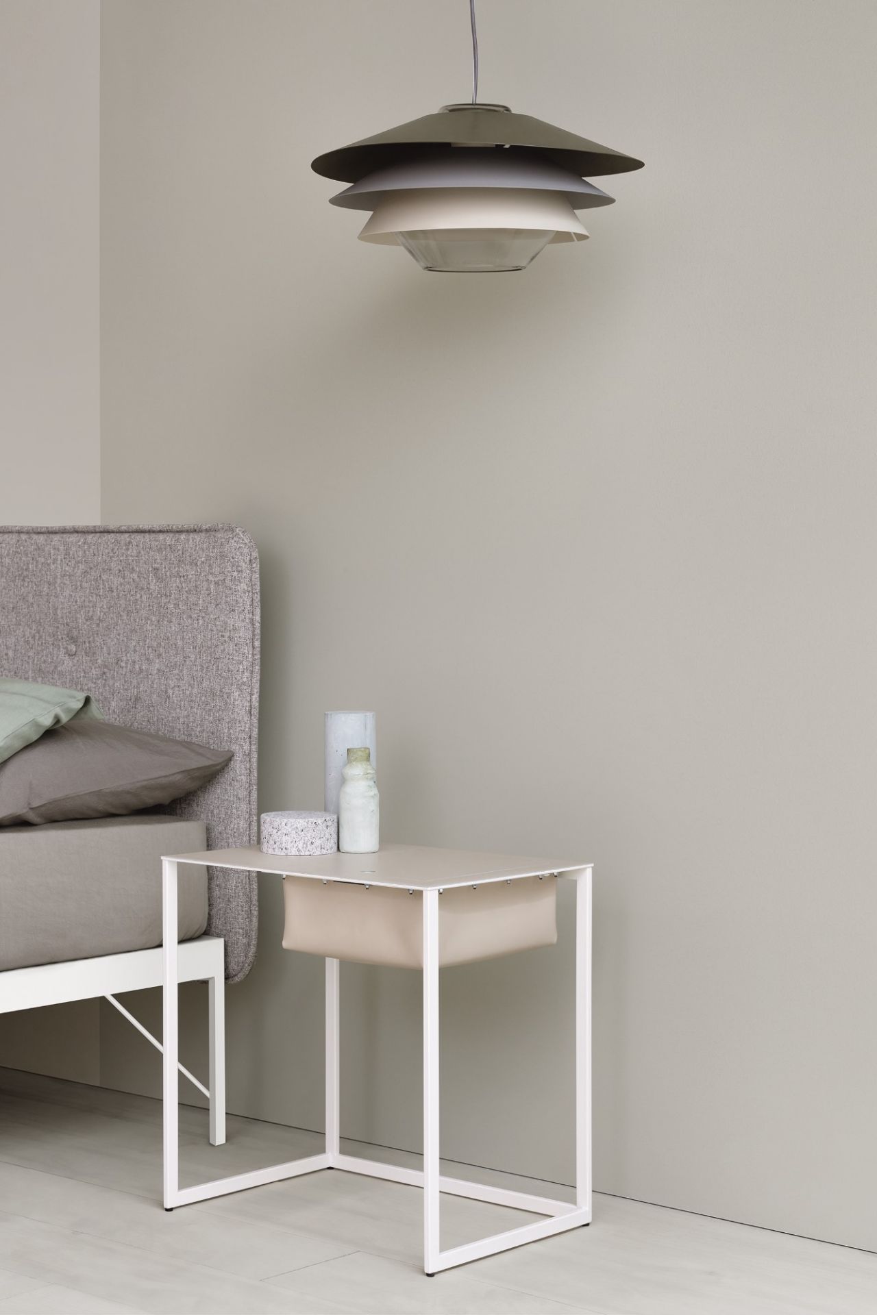 Taschino Nachttisch von Zanotta in Beige mit weißem Metallgestell und Stoffablage neben Bett.