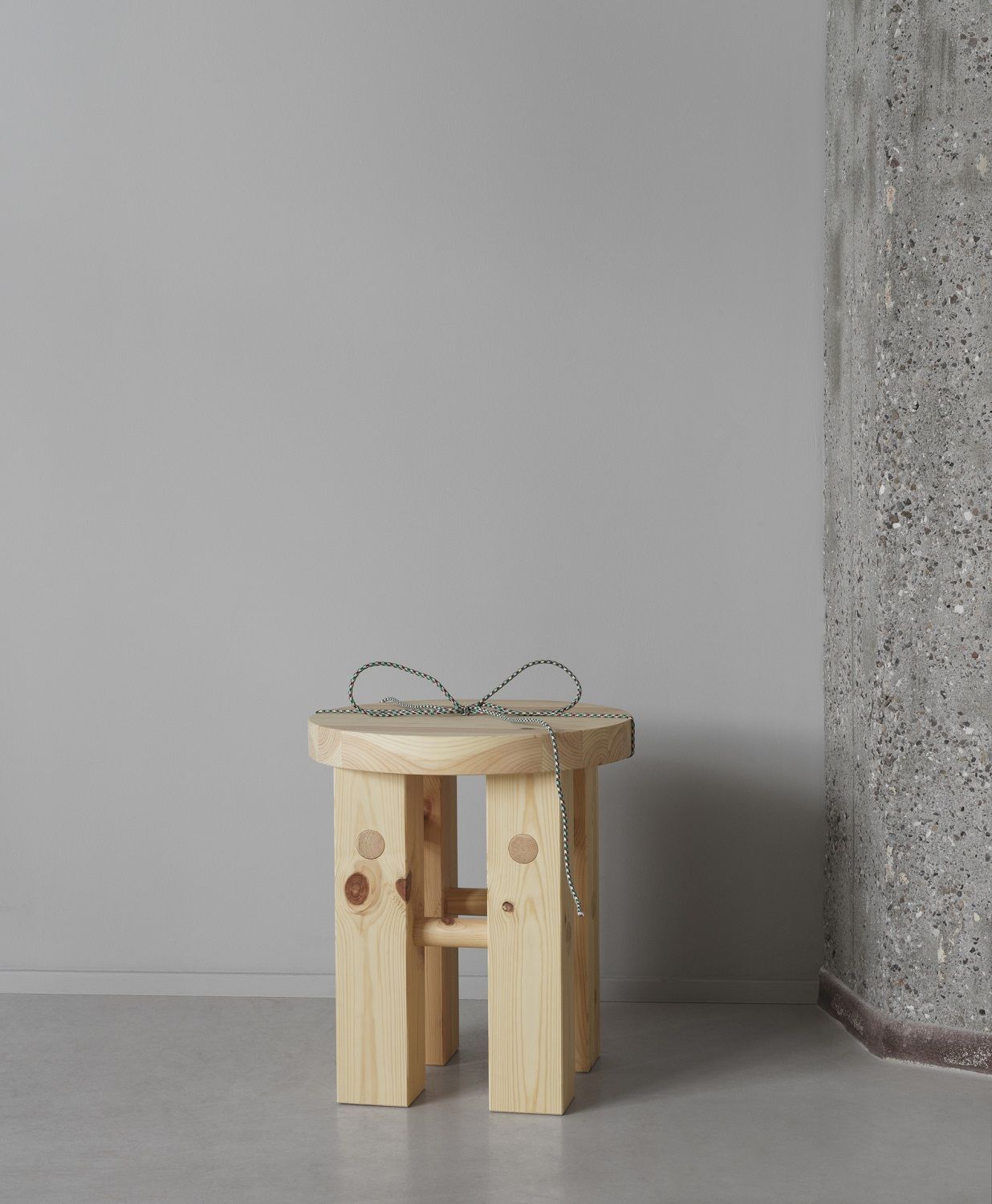Fyr Stool Hocker von Normann Copenhagen aus hellem Holz mit Schnur auf Sitzfläche.