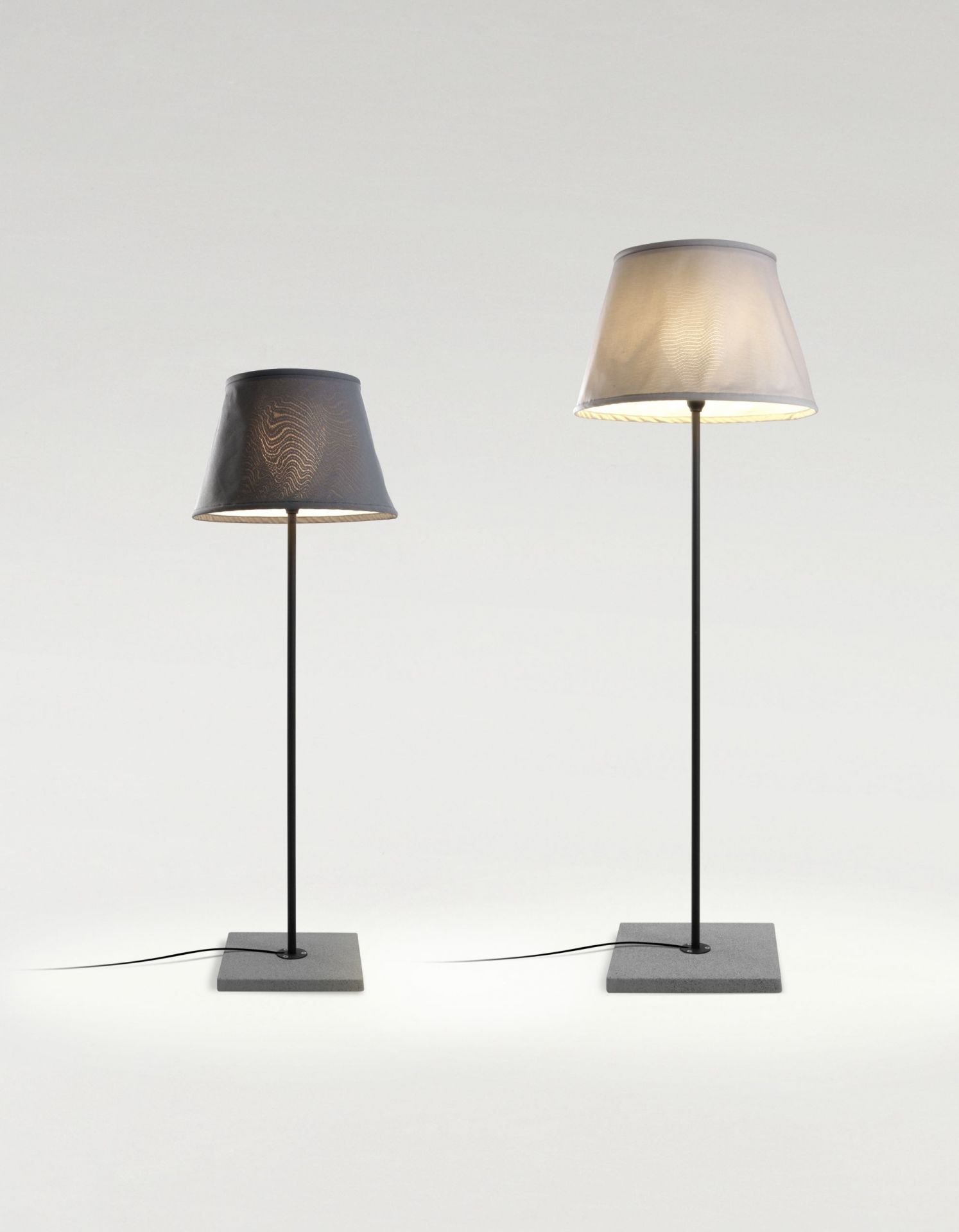 Zwei TXL Stehleuchten von Marset in Beige und Grau für den Außenbereich.