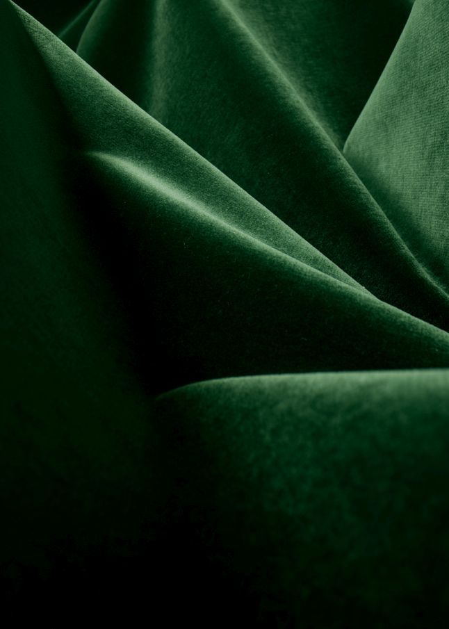 Detailaufnahme: Grüner Samtbezug des Beetle Chair Stuhls von Gubi, luxuriöses Möbeldesign.