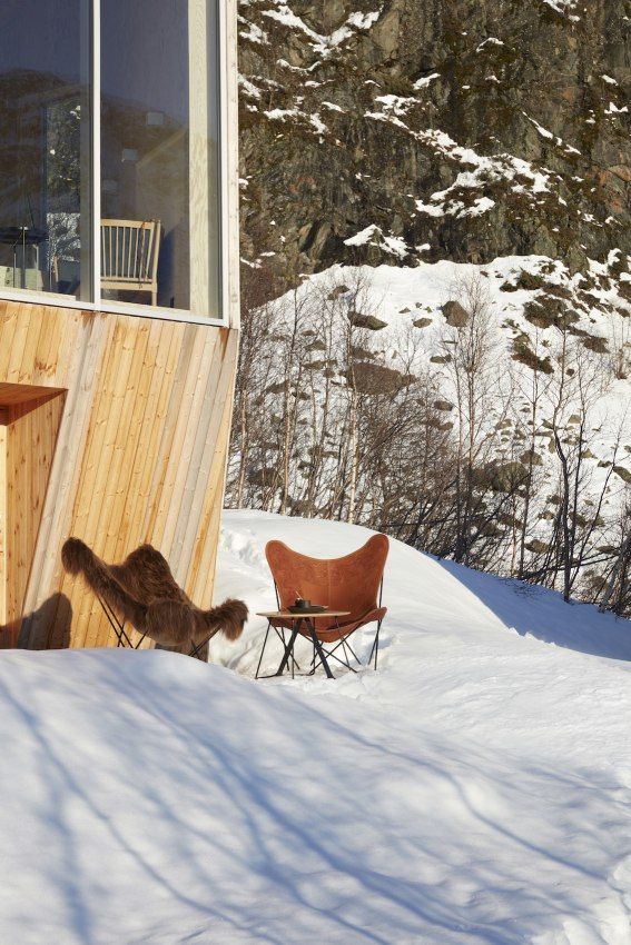 Iceland Mariposa Butterfly Chair Sessel Schaffell und Cuero Leder im Schnee vor einem Haus.