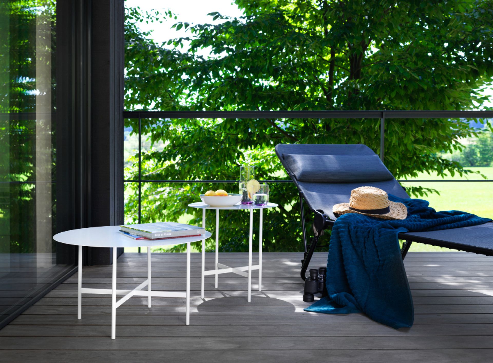 BETA Couchtisch und Beistelltisch von Müller Möbelfabrikation in Rauch matt auf einer Terrasse.