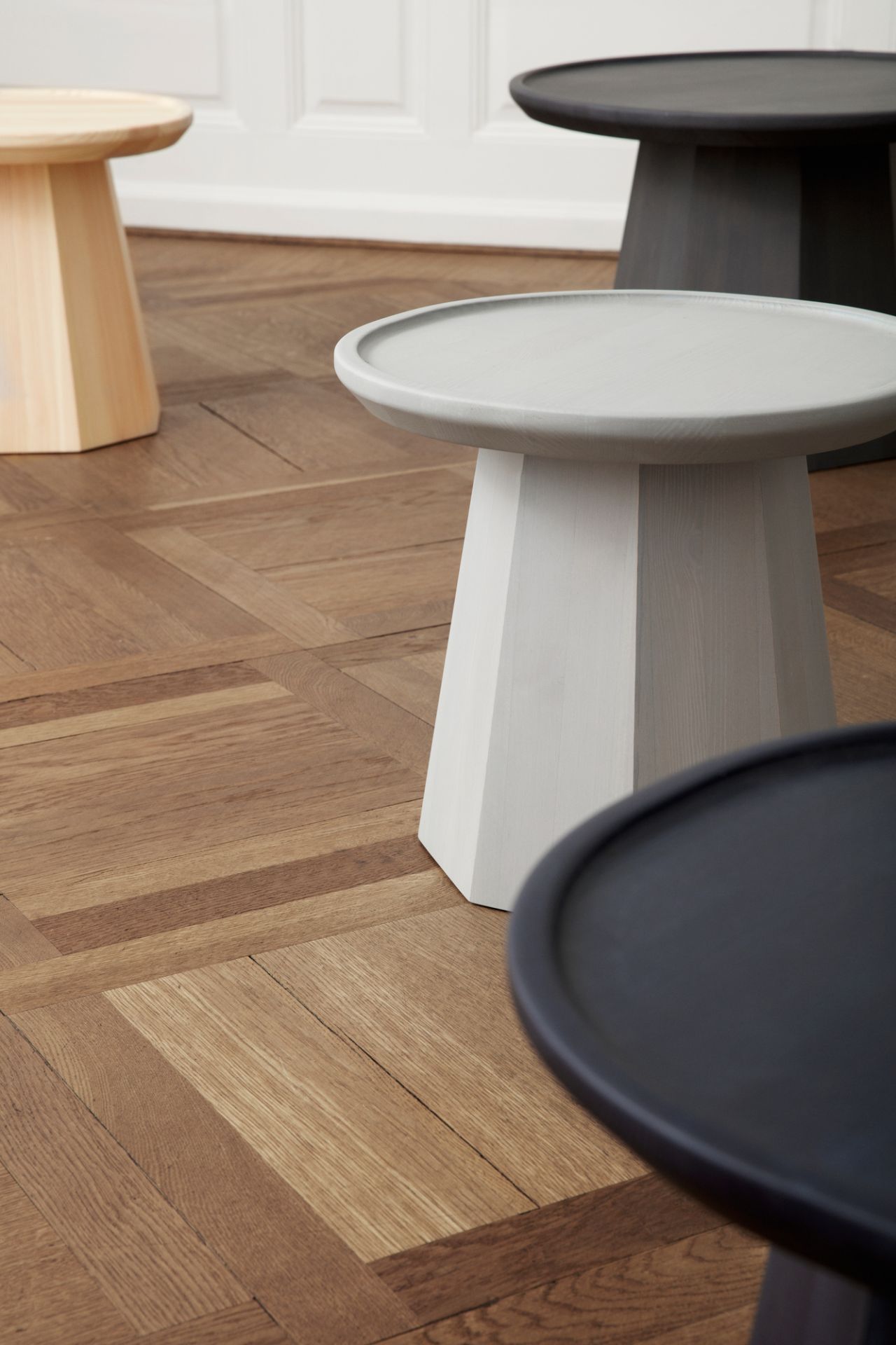 Nahaufnahme von mehreren Normann Copenhagen Pine Table Beistelltischen in verschiedenen Farben.