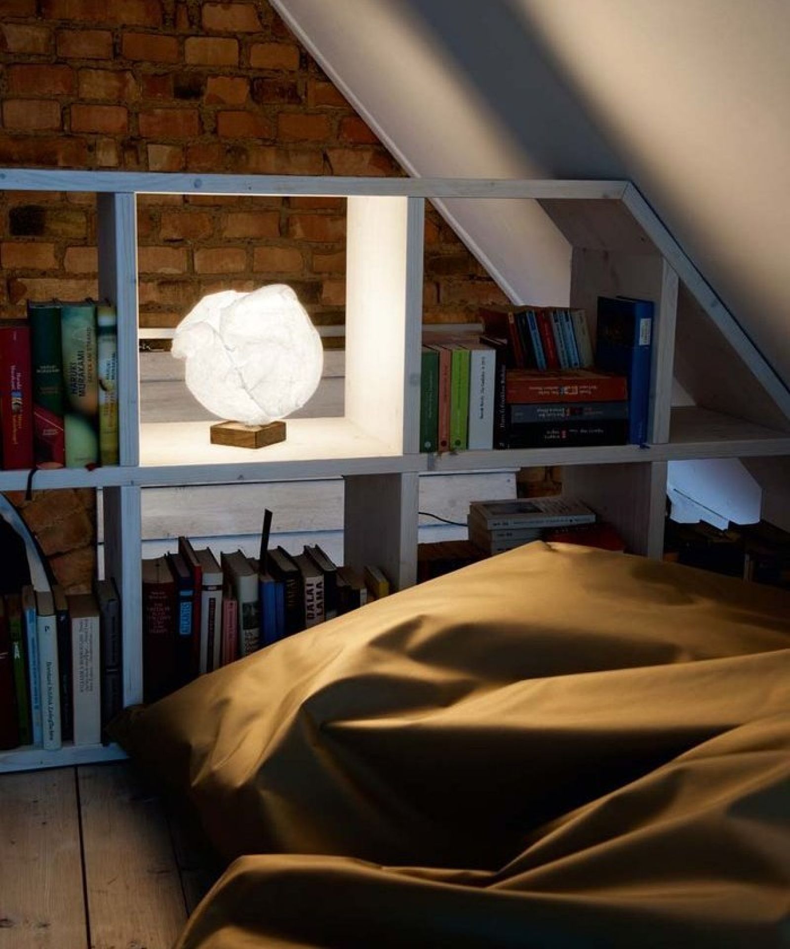 Babycloud Tischleuchte Belux auf Regal, weiße Papierlampe für stimmungsvolle Beleuchtung im Wohnzimmer.