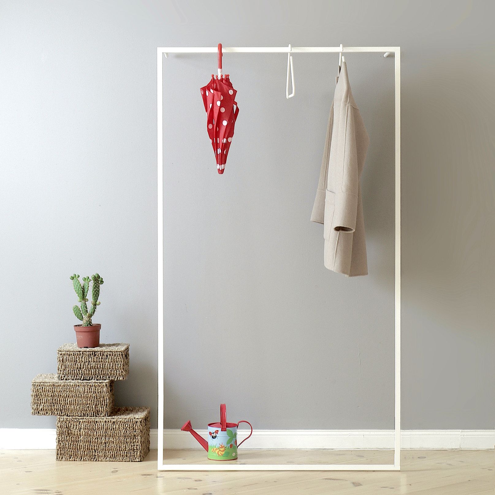 Weiße Leano Anlehngarderobe von Roomsafari mit Mantel und Schirm, minimalistisches Design für Flur und Schlafzimmer.