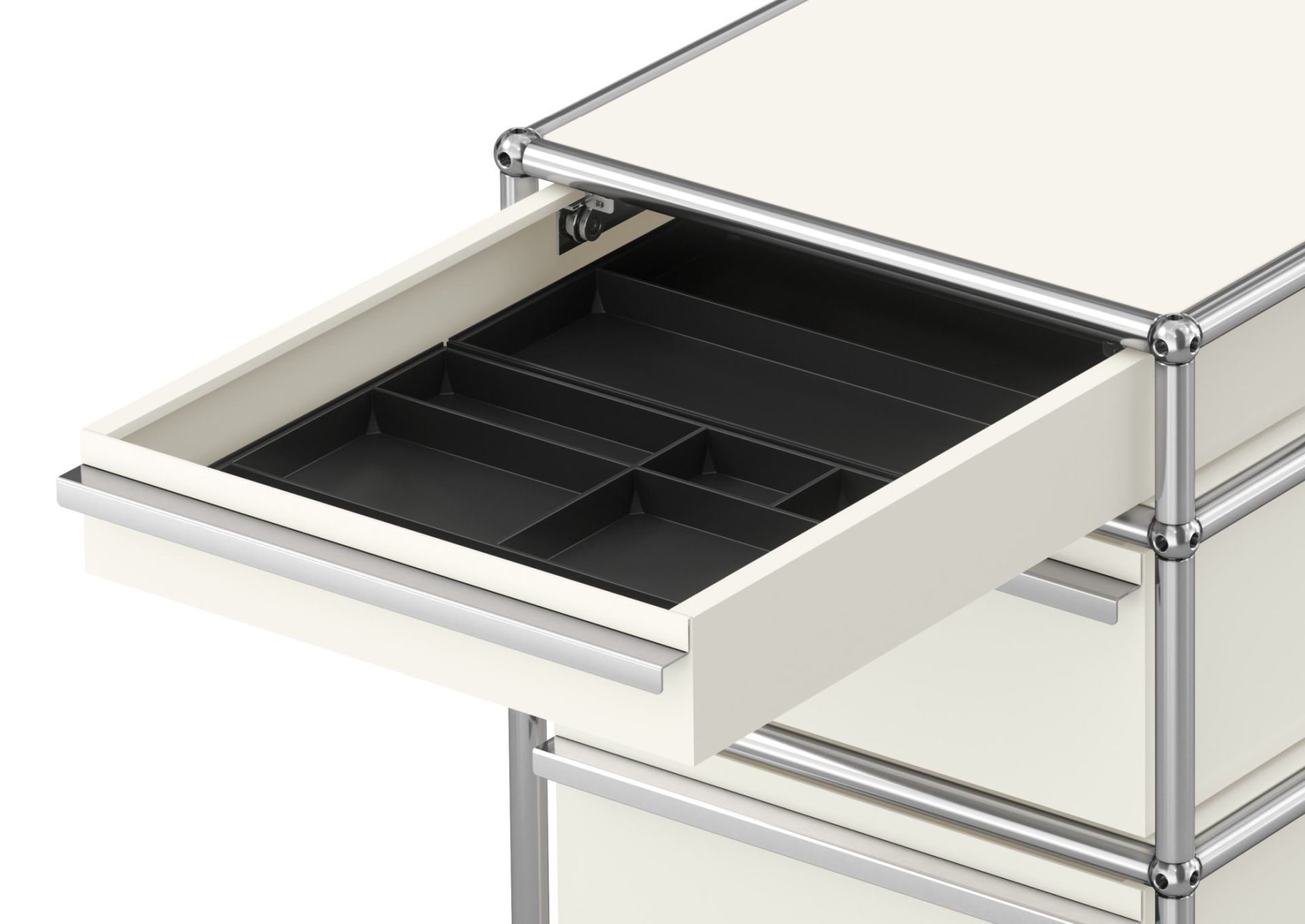 Detailaufnahme: Reinweißer USM Haller Rollcontainer mit drei Schubladen, eine Schublade ist geöffnet und zeigt eine schwarze Facheinteilung.