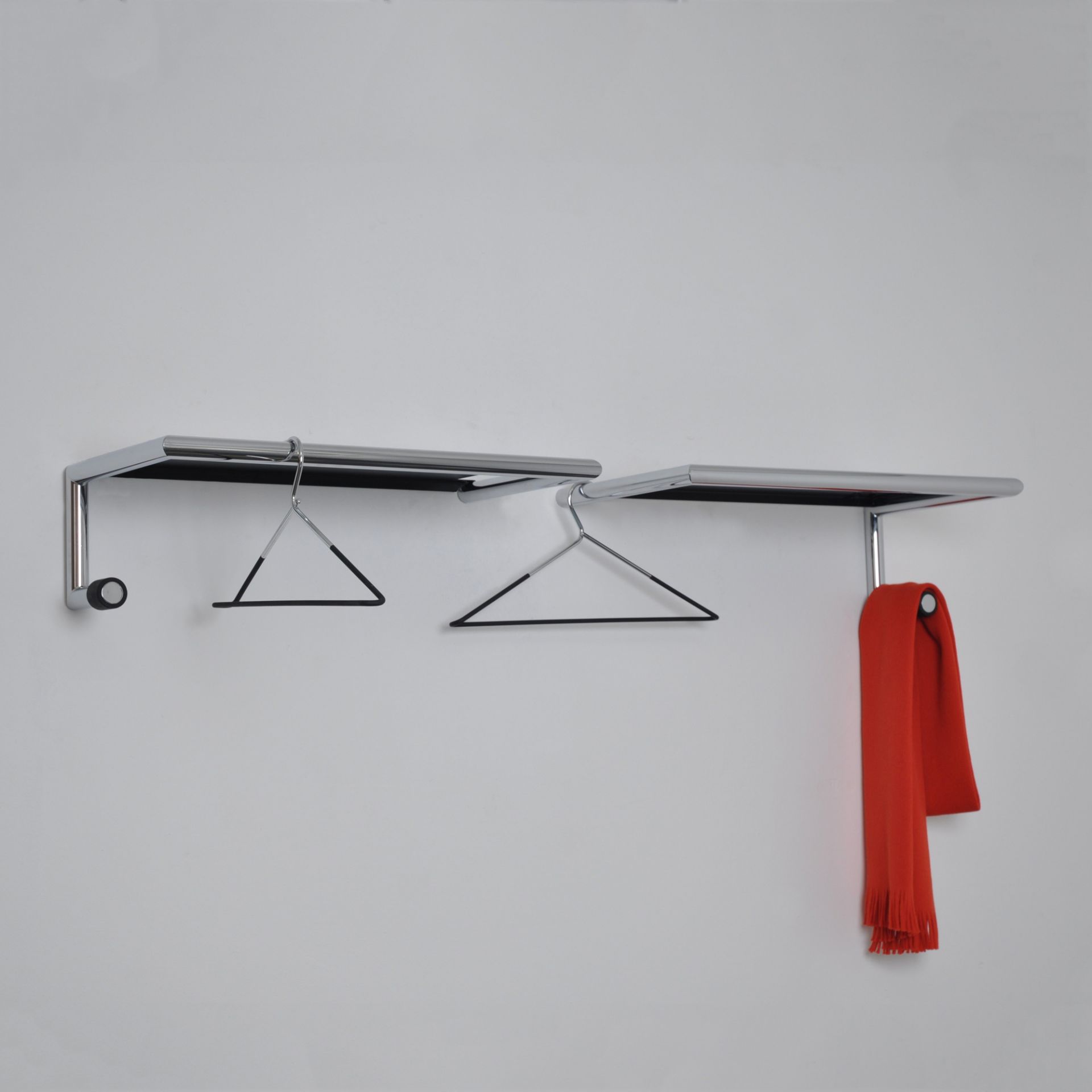 Link 55 Wandgarderobe mit Hutablage Mox: Chromfarbene Garderobe mit Haken und rotem Schal.