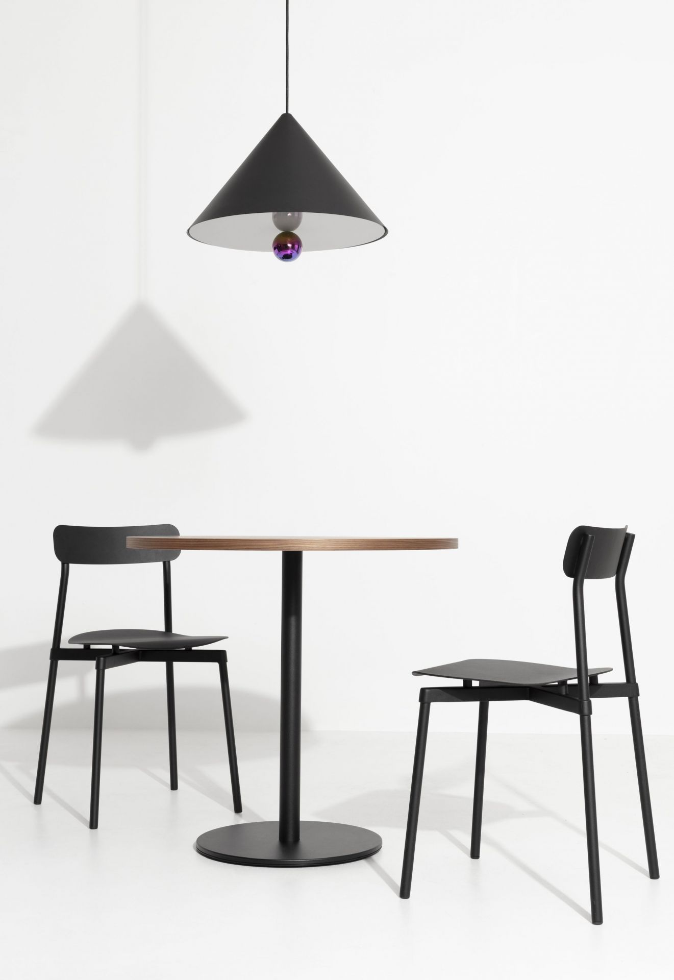 Schwarze Cherry Pendelleuchte von Petite Friture über Esstisch mit zwei Stühlen. Design Lampe.