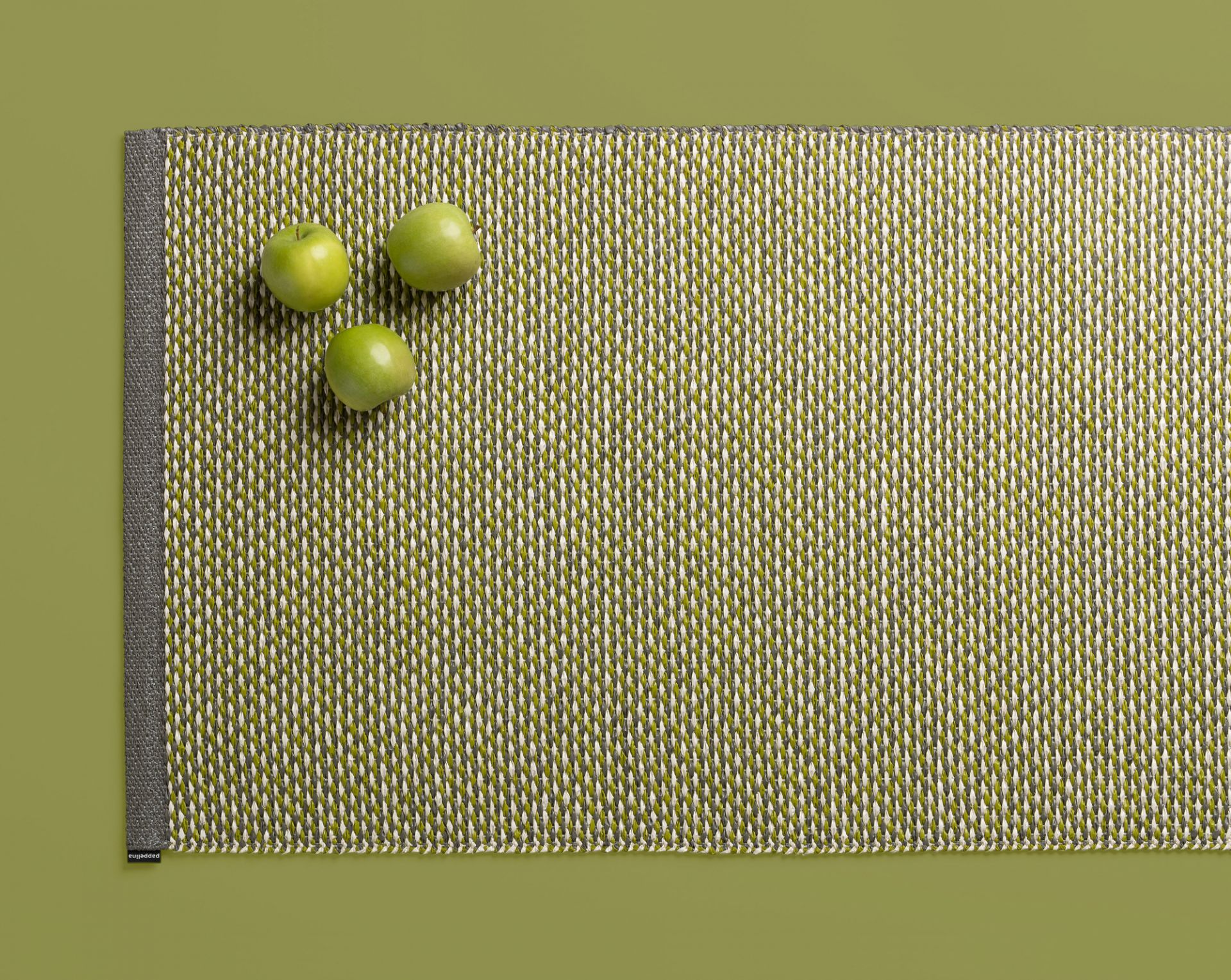 Effi Kunststoffteppich von Pappelina, 70x200 cm, in Grün-Weiß mit drei grünen Äpfeln.