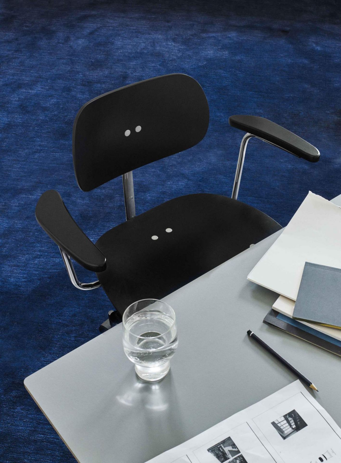 Schwarzer SBG 197 R Drehstuhl von Wilde+Spieth am Schreibtisch mit Glas Wasser.