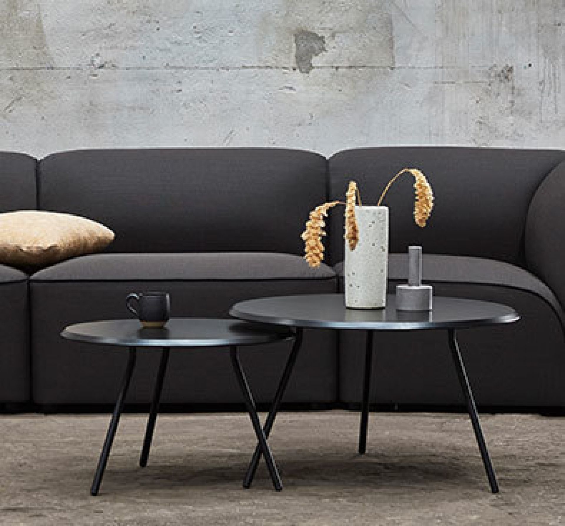 Schwarzer Soround Coffee Table Couchtisch von Woud, runder Beistelltisch aus Metall vor dunklem Sofa.