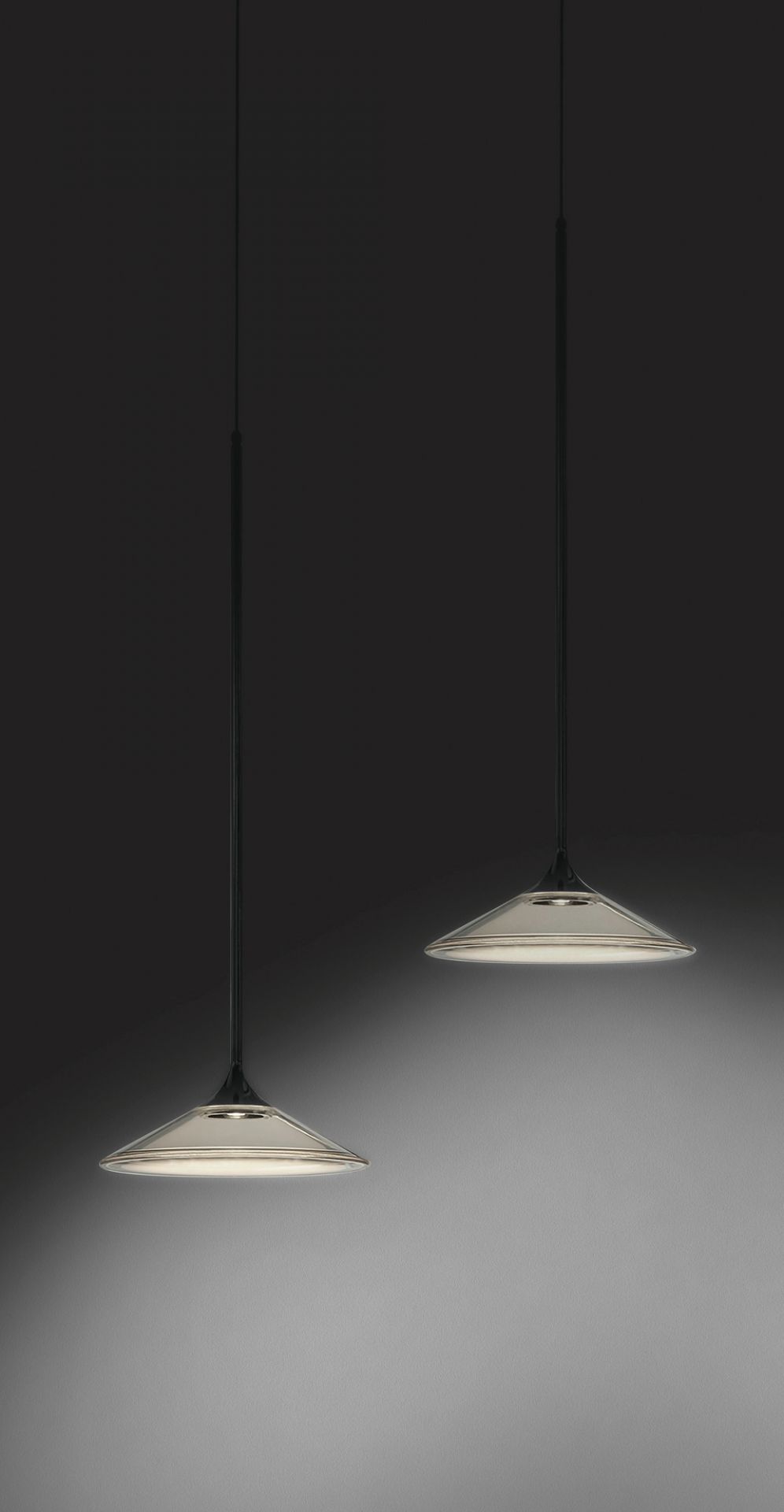 Zwei moderne Orsa Pendelleuchten in Schwarz von Artemide, minimalistisches Design, indirekte Beleuchtung.