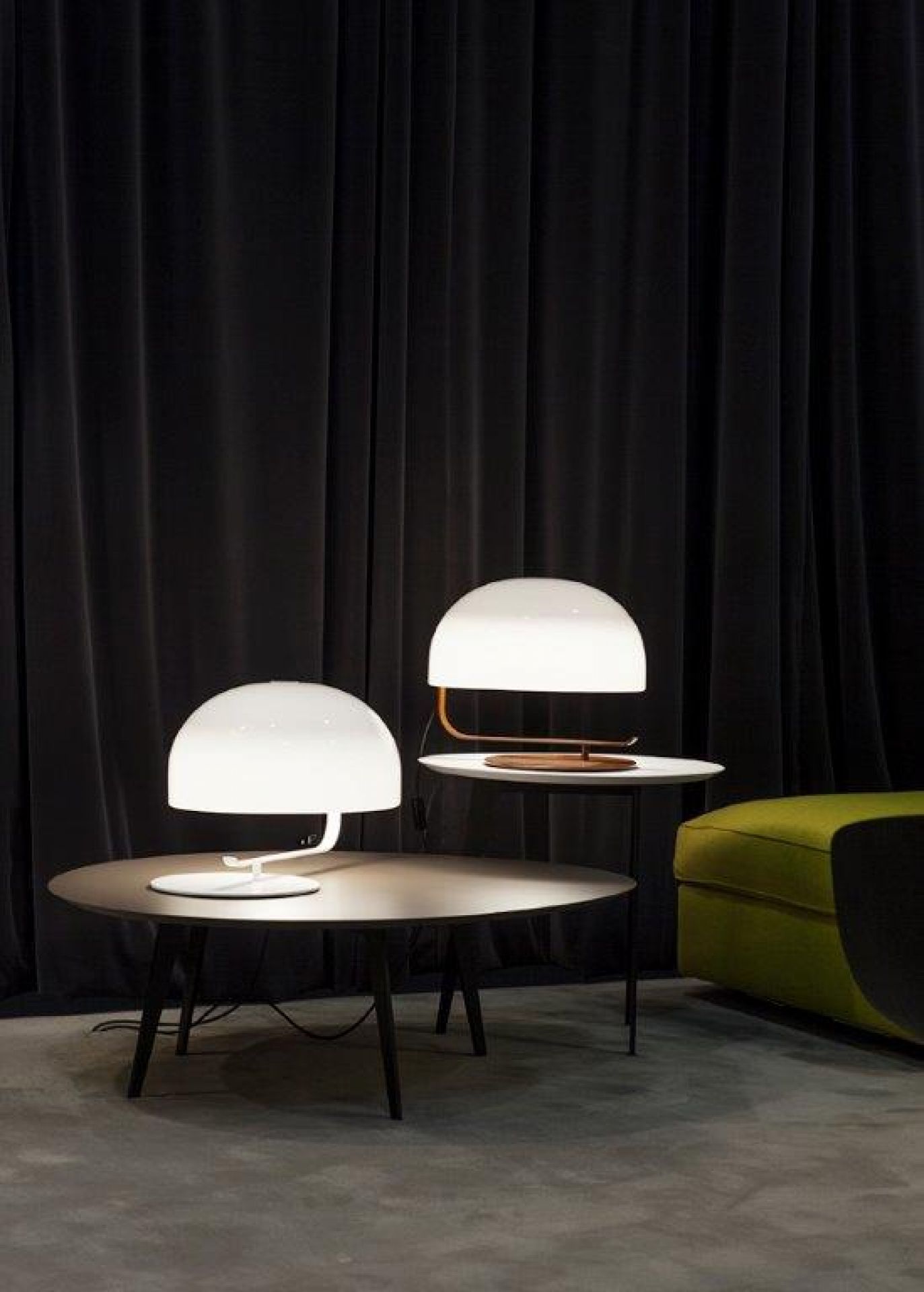 Zwei Zanuso Tischleuchten von Oluce auf Tischen vor einem dunklen Vorhang, modernes Design.