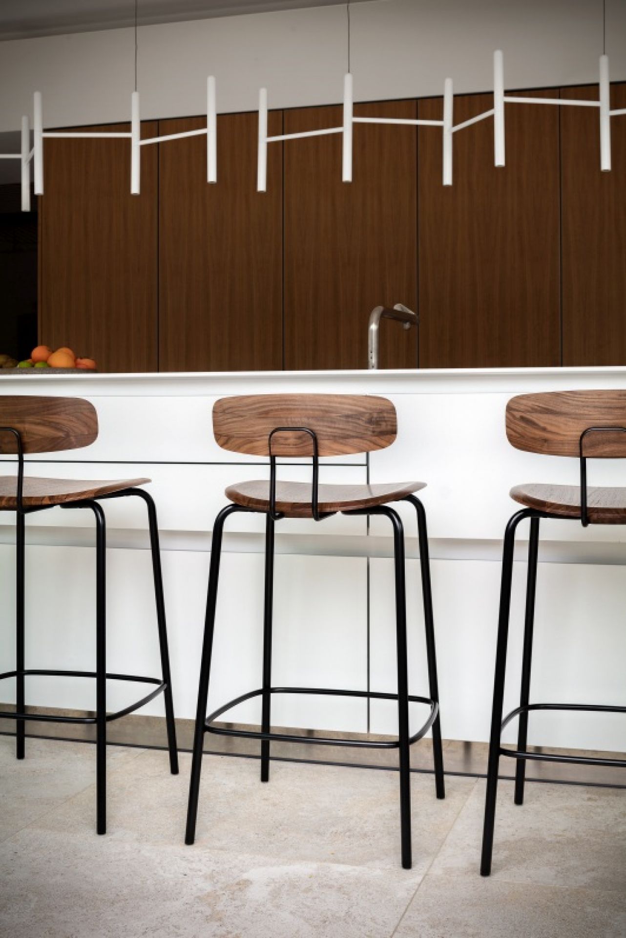 Drei Okito Barstool Barhocker mit Holzsitzen und schwarzem Gestell vor einer Küchentheke.
