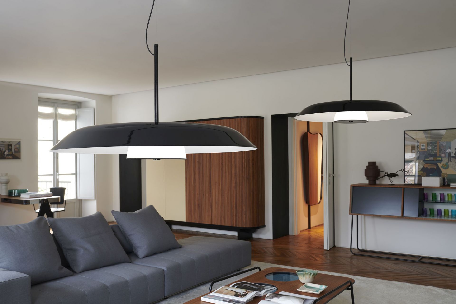 Zwei schwarze Oluce Iride Pendelleuchten im Wohnzimmer, moderne Hängelampe Designleuchte.