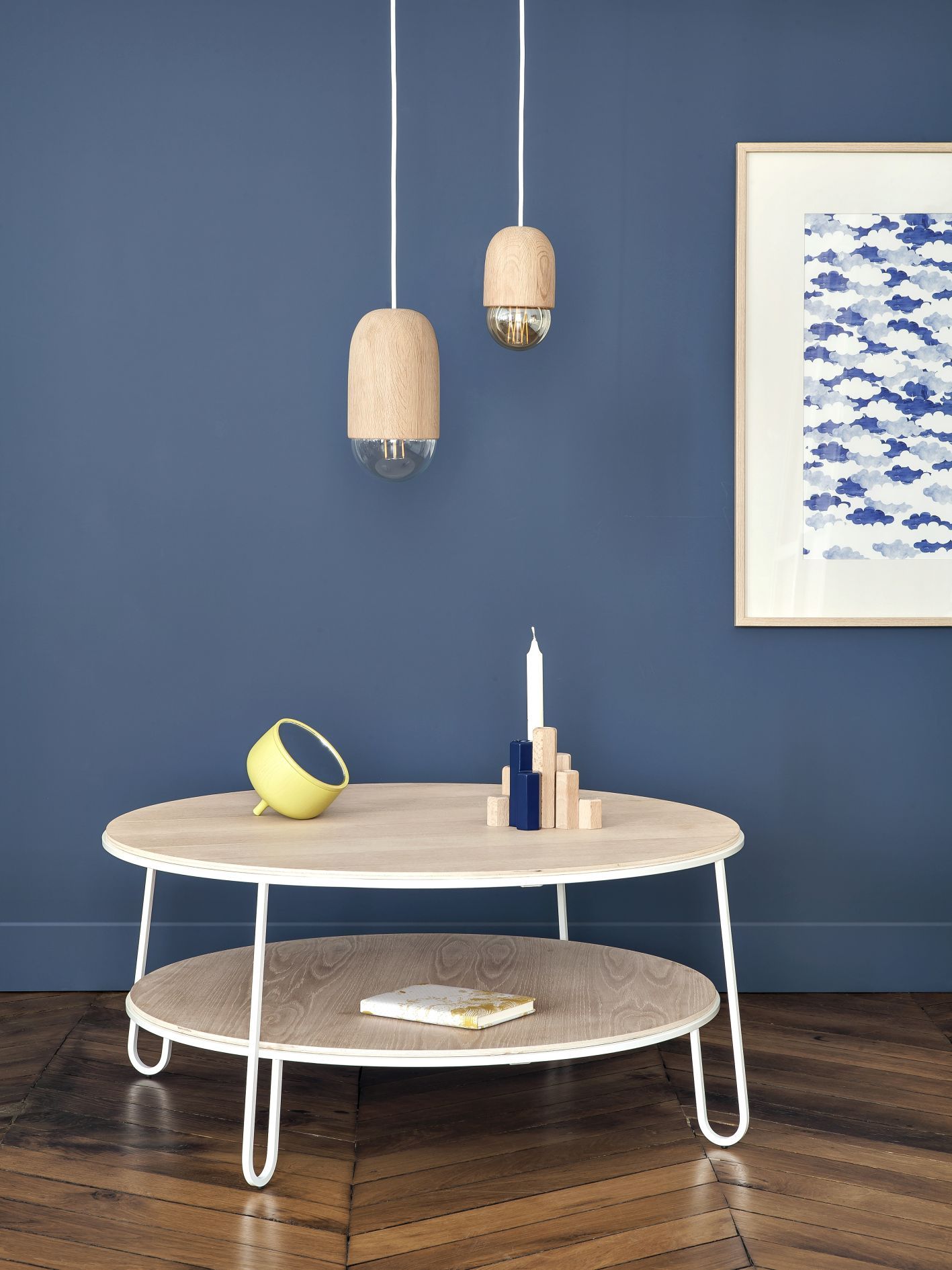 Eugenie Couchtisch von Hartô, runder Holztisch mit Ablage, weißem Gestell und Dekoration.