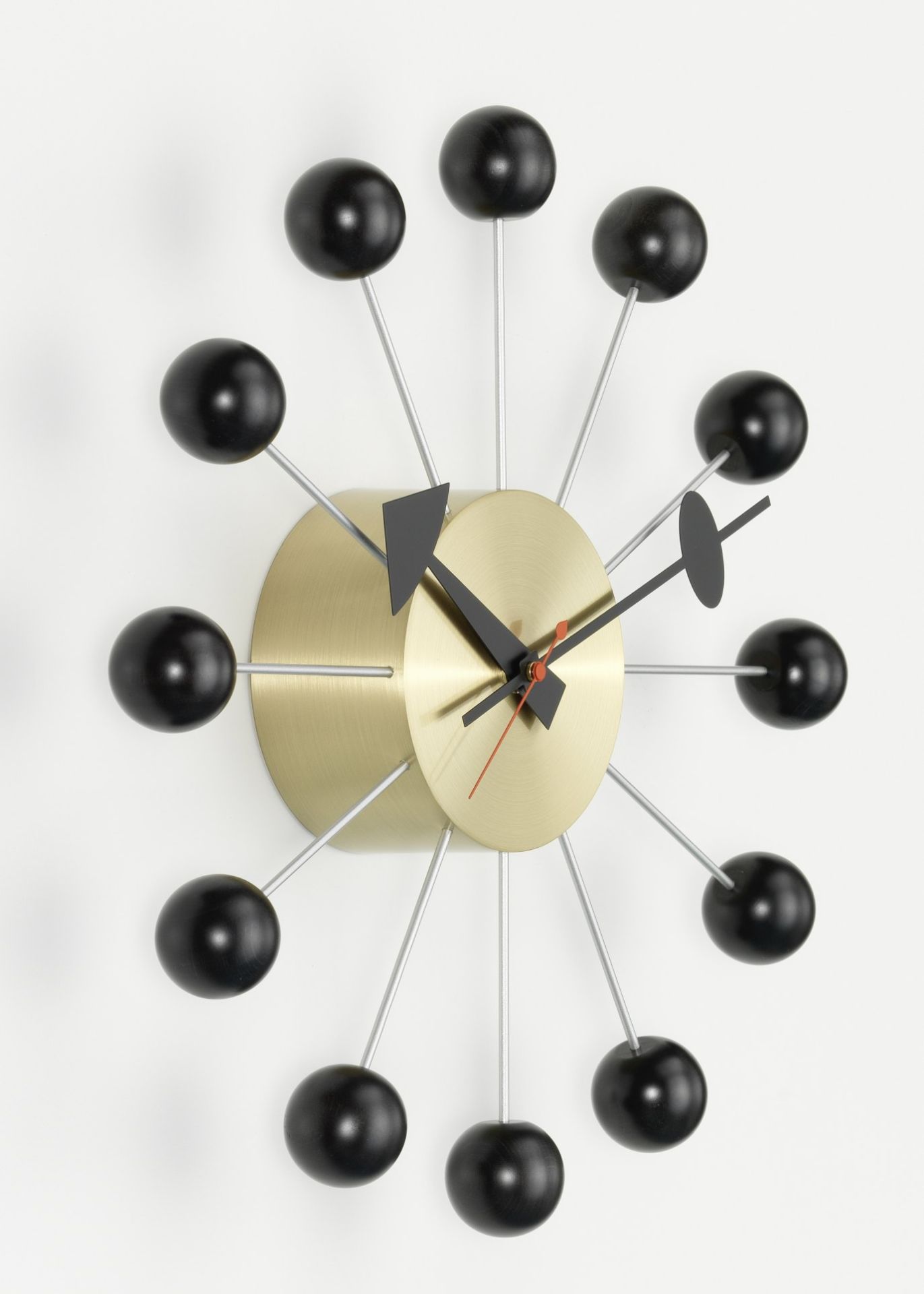 Nahaufnahme der Vitra Ball Clock Wanduhr in Schwarz mit goldenem Ziffernblatt.