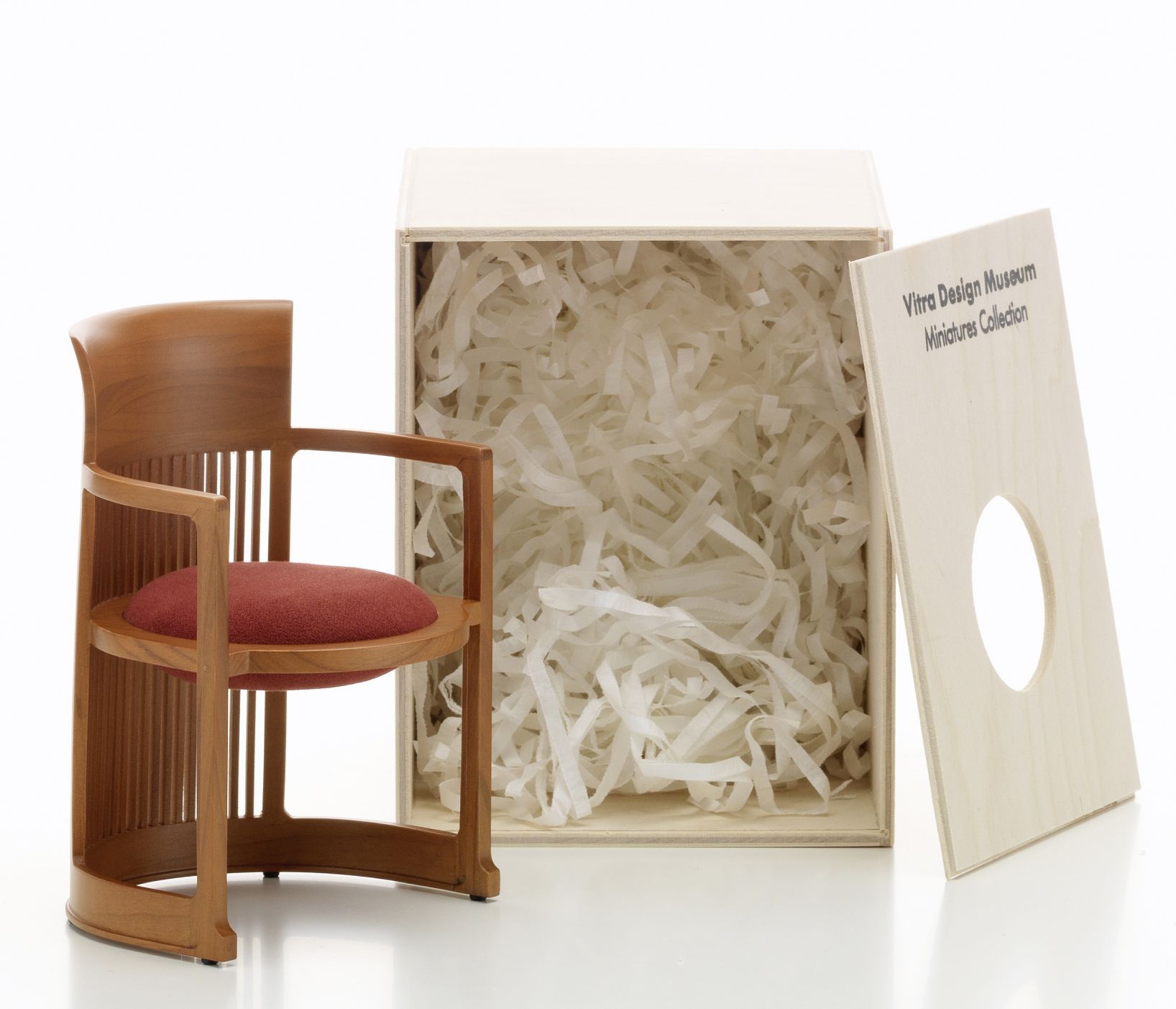 Barrel Chair Miniatur Stuhl von Vitra mit rotem Sitzkissen und zugehöriger Holzbox.