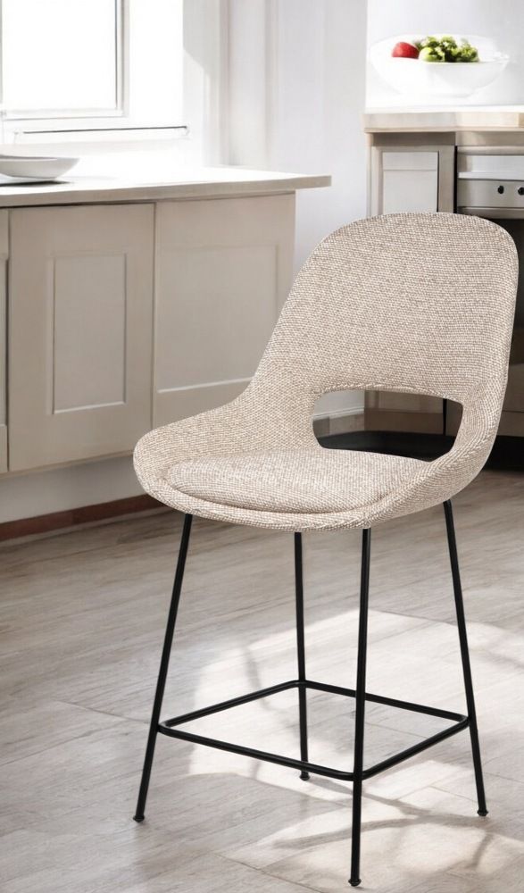 Theia Kitchen Armchair Barstool von Freifrau Manufaktur, niedriger Barhocker mit beigem Stoffbezug und schwarzem Metallgestell.