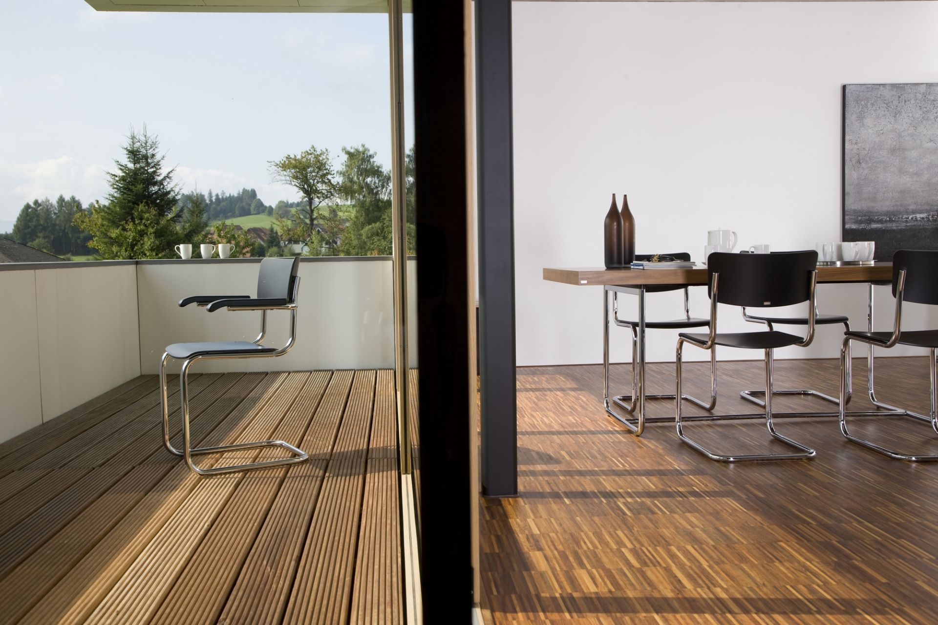 S 1071 Thonet Esstisch ausziehbar mit Freischwinger Stühlen in modernem Interieur und Balkonansicht.