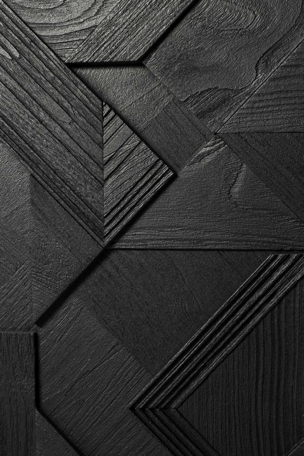 Detailaufnahme der schwarzen Graphic Teak Anrichte von Ethnicraft mit geometrischen Mustern und Holzstruktur.