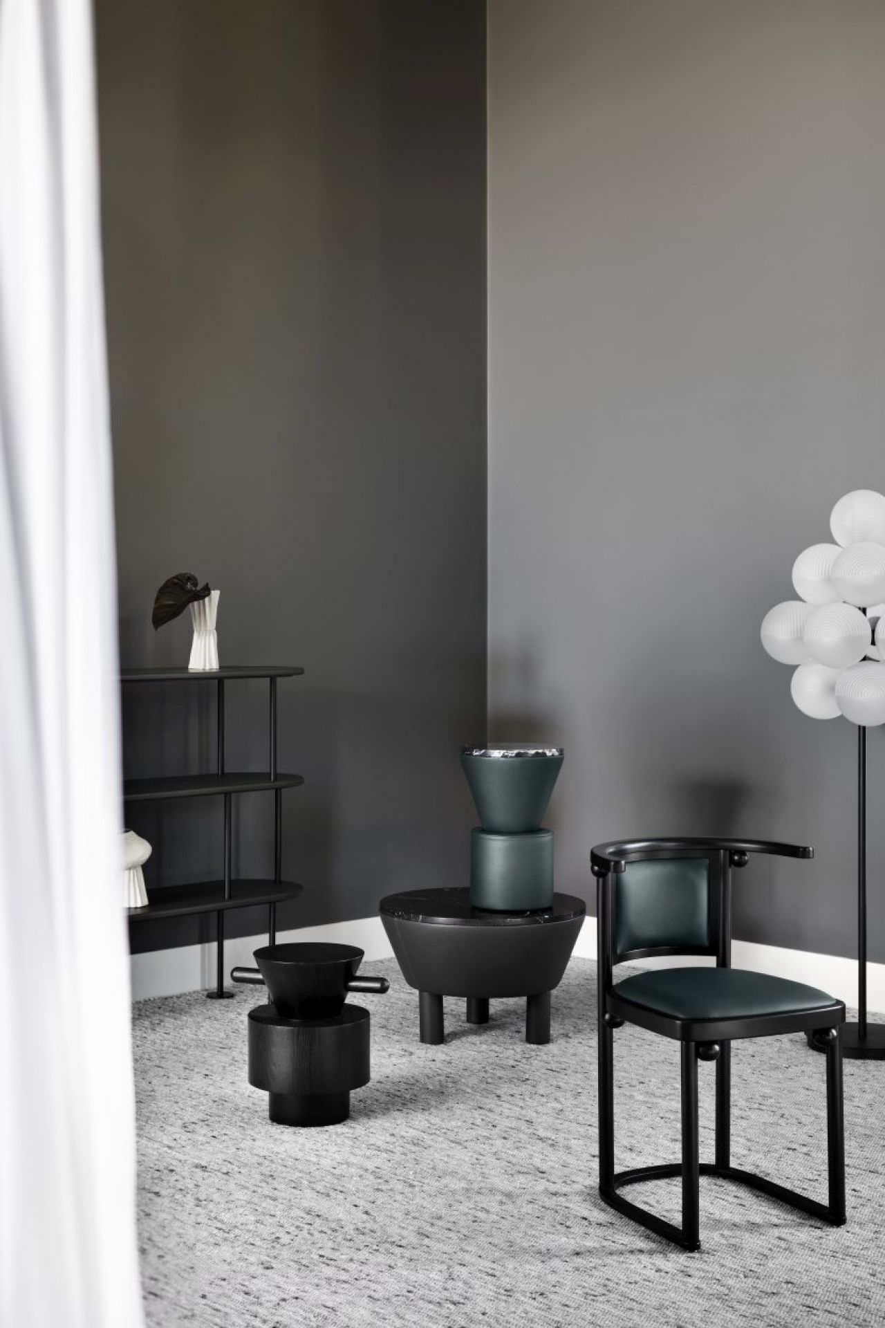 Stilvolles Interieur mit Stellar Grape Stehleuchte von Pulpo, transparenten Kugeln und schwarzem Gestell.